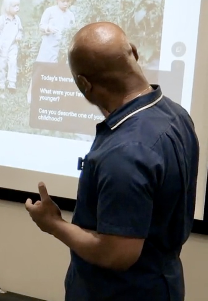 A facilitator using the prompts on the Ayla screen to guide a cognitive stimulation therapy session.