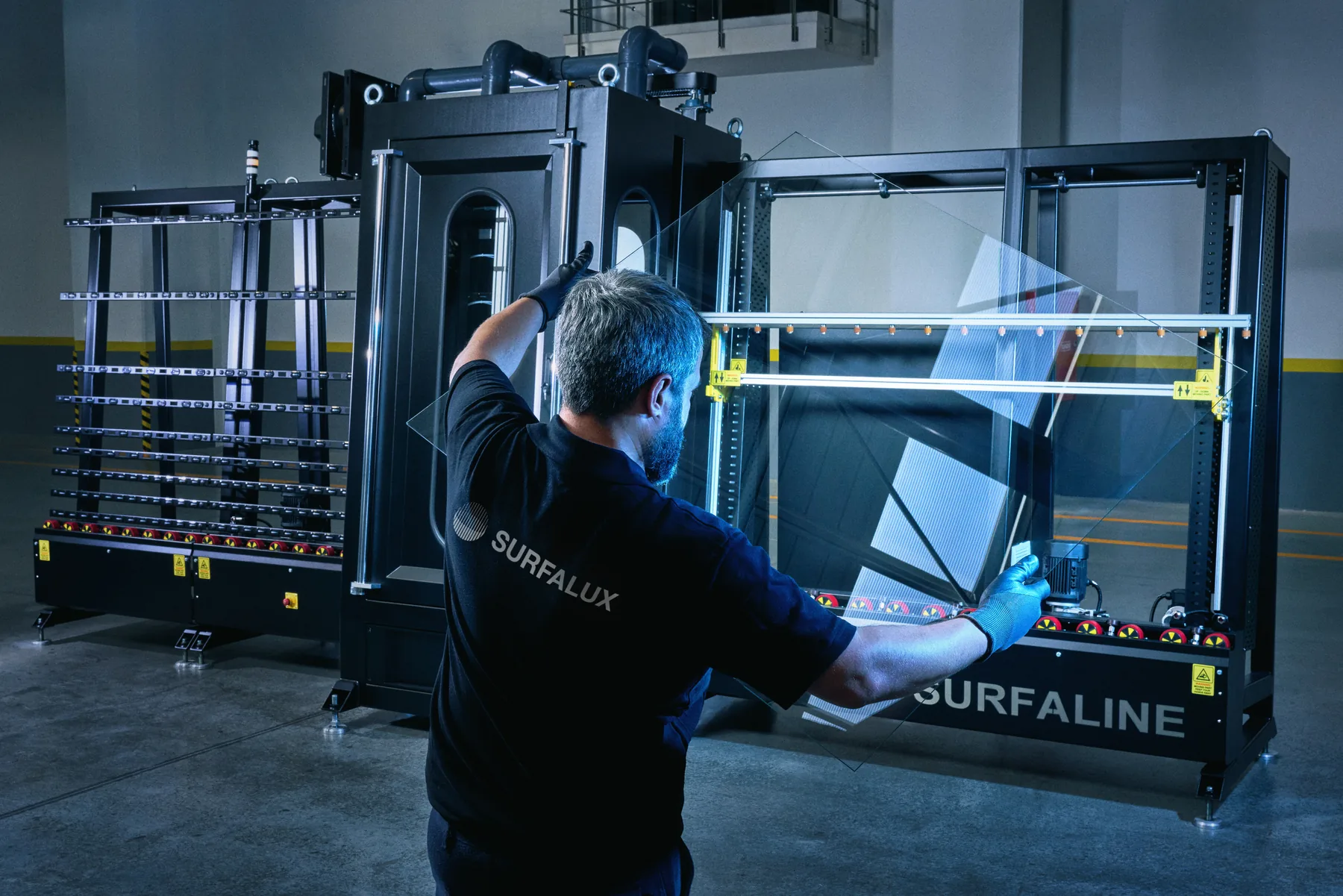 Technician loading a glass panel into the SurfaLine machine