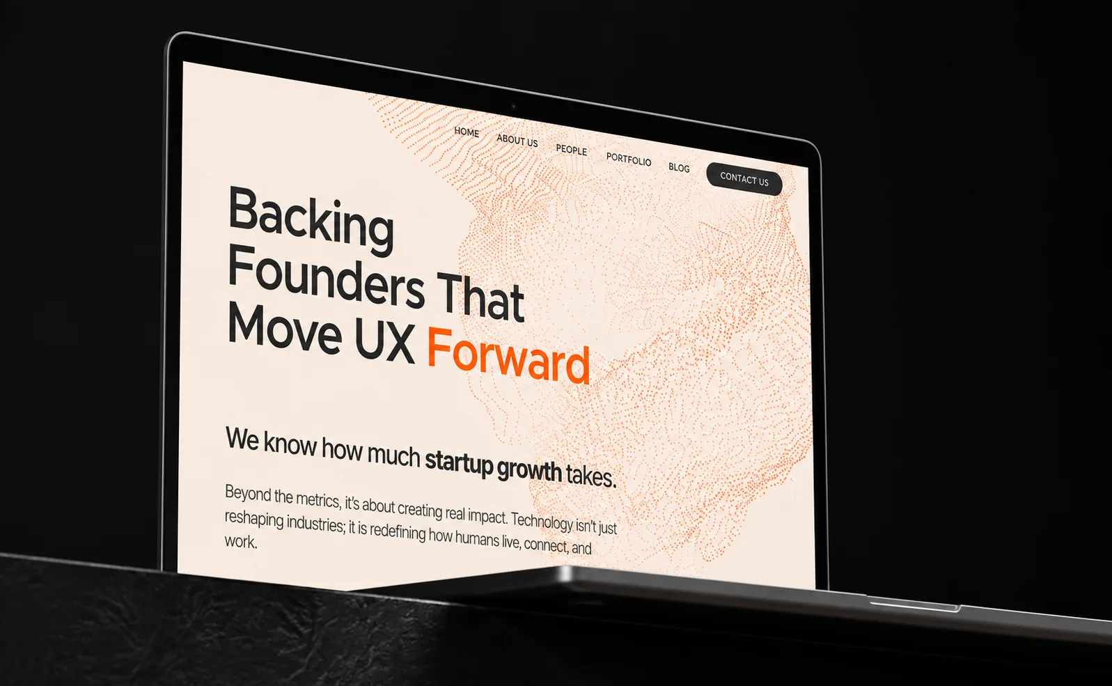Laptop screen showing a website with text about backing founders and advancing UX design.