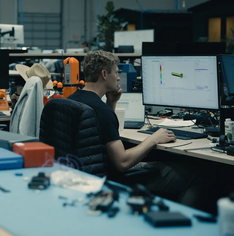 Engineer at workstation operating CAD software for Archer drone.