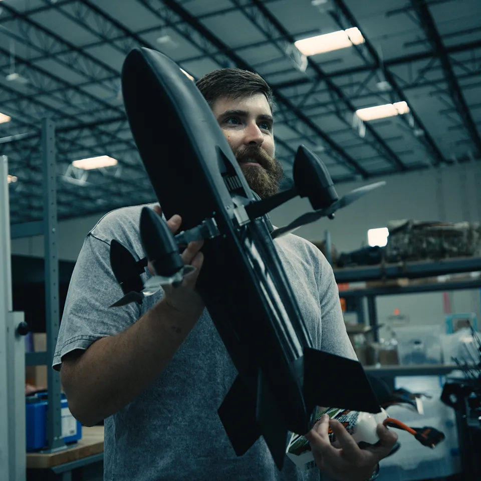 Neros engineer holding Bandit, Neros' interceptor drone.