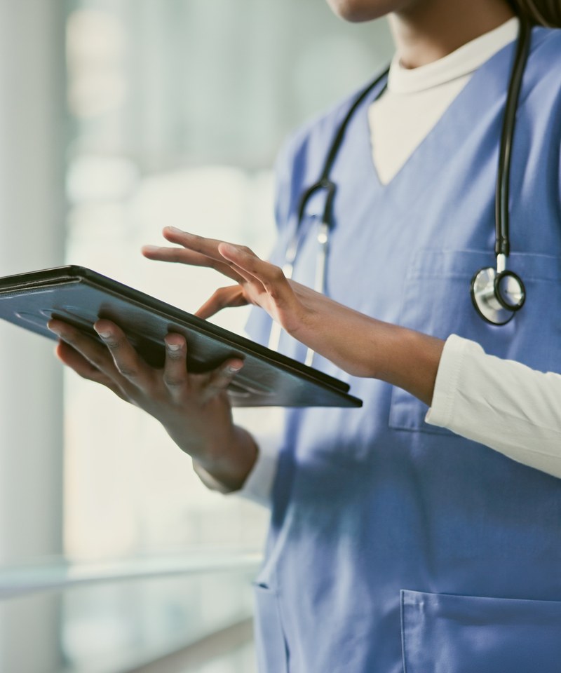 Healthcare professional using a tablet on the floor