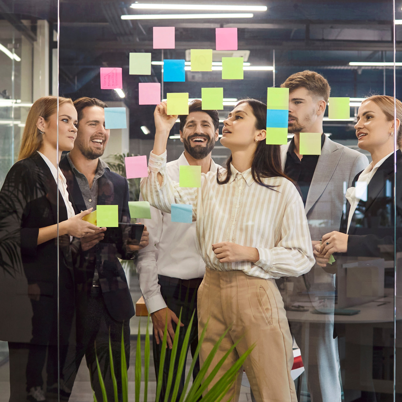 Team working through a planning session on a glass wall