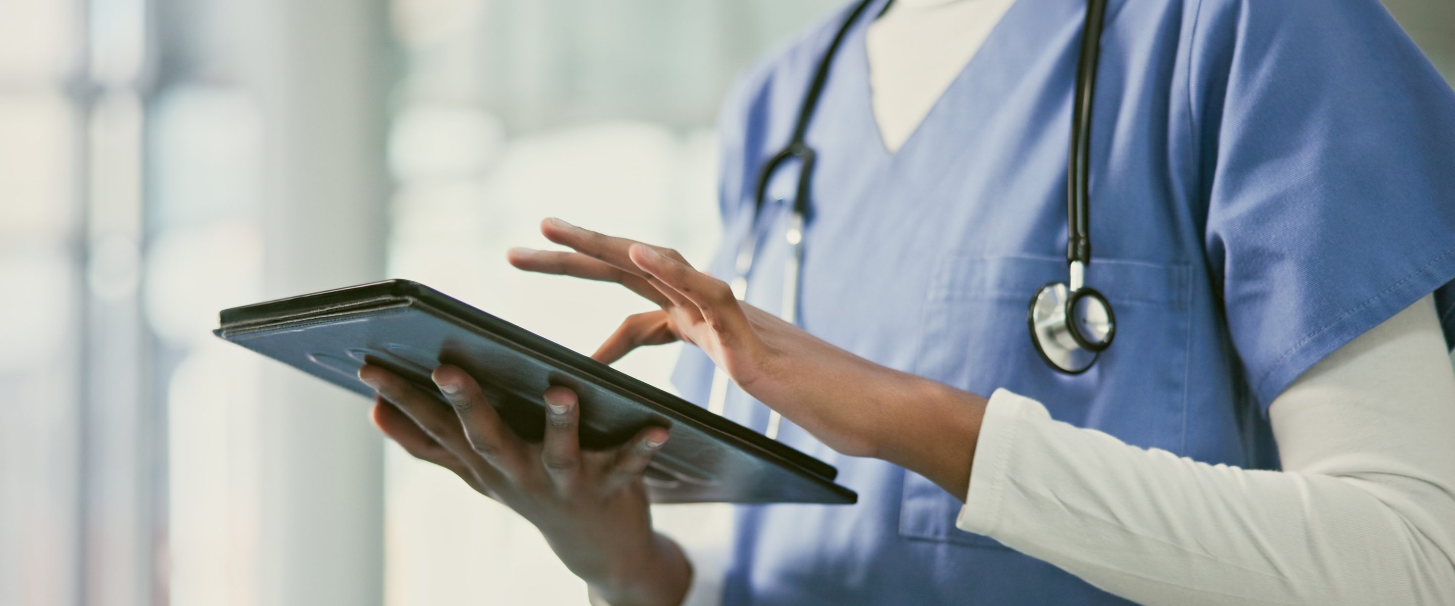 Healthcare professional using a tablet on the floor