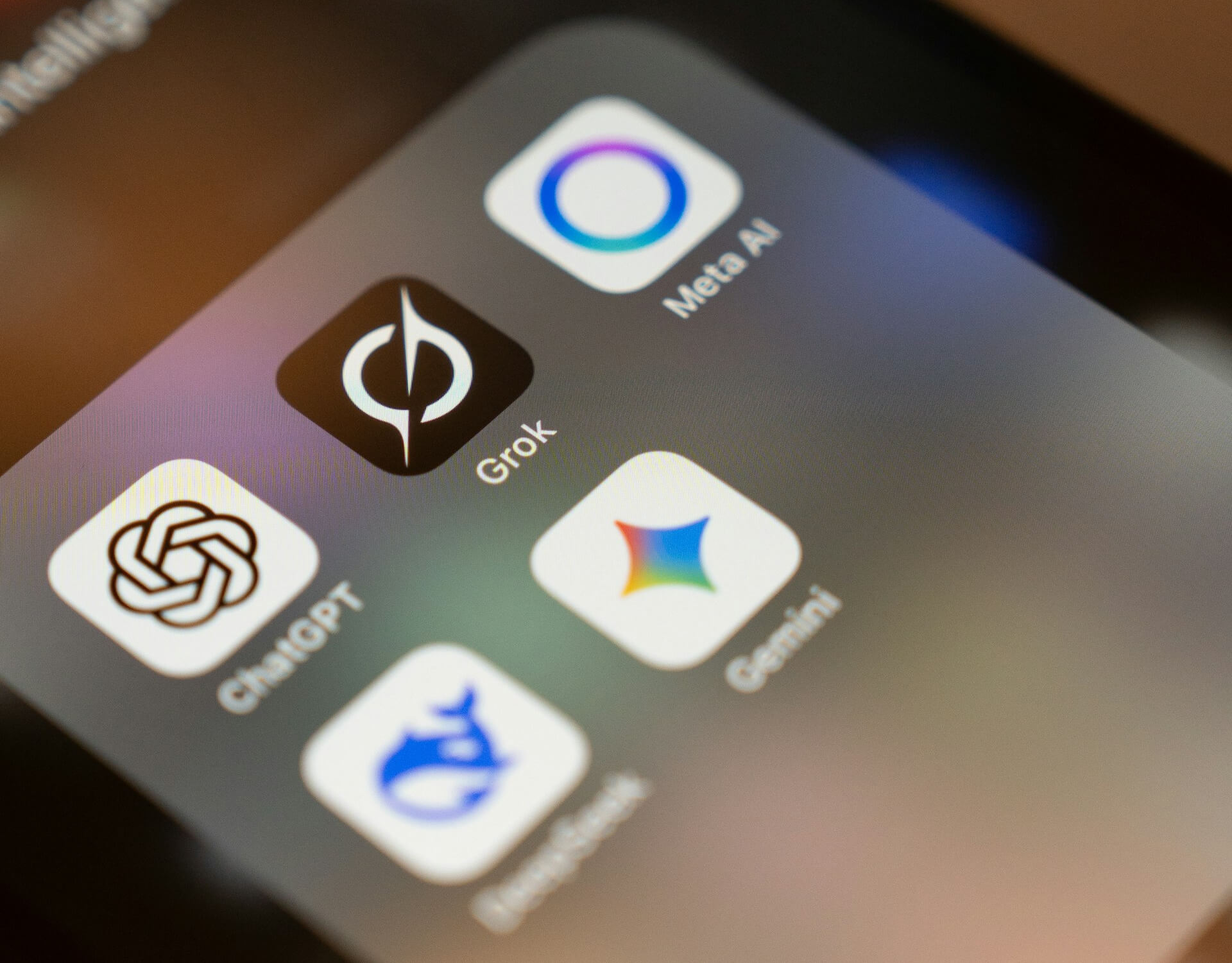 Smartphone screen showing a folder of popular AI assistant apps, representing the AI agents businesses now run