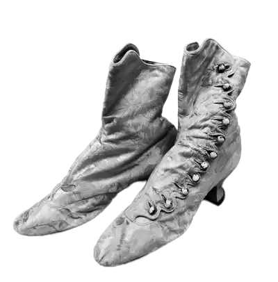 Pair of vintage women's Victorian-style ankle boots made of satin fabric with button closures on the side and low curved heels.