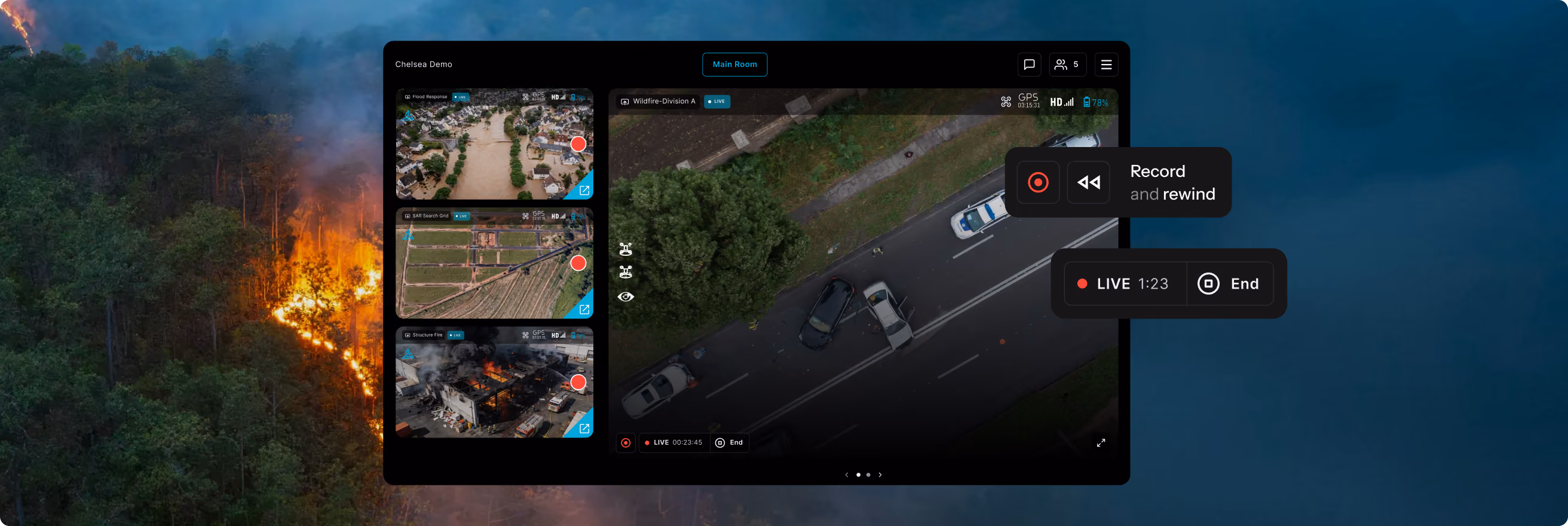 Screenshot of a monitoring dashboard showing live video feeds of emergency situations including a flooded residential area, a search grid over farmland, and a building fire, alongside a larger live aerial view of a road incident with multiple cars and emergency responders on a tree-lined street.