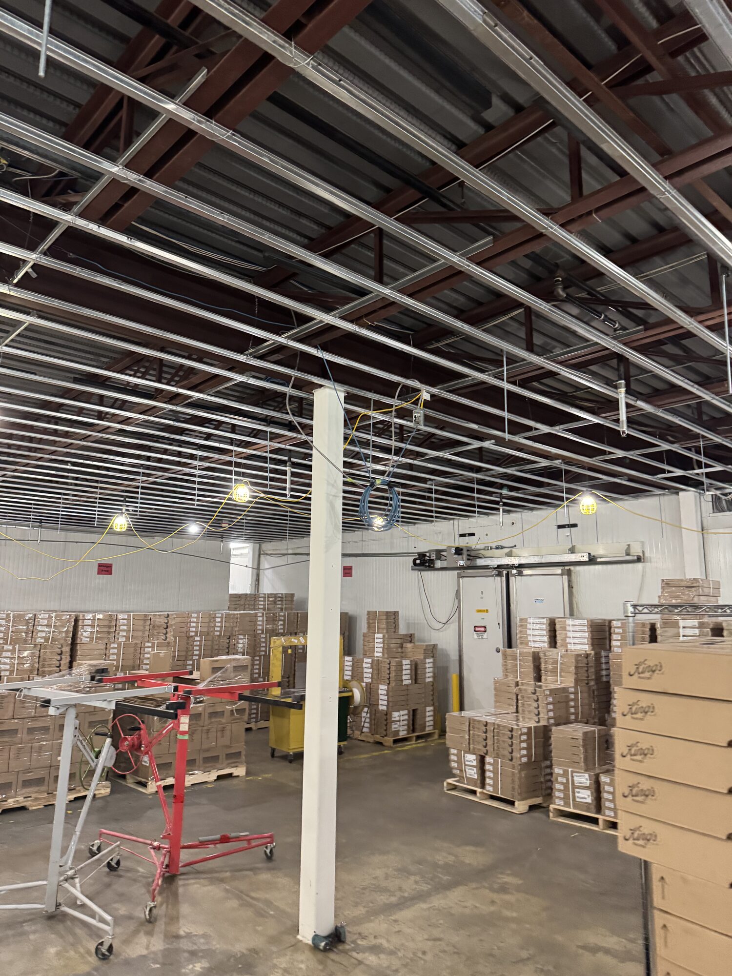 New ceiling framing installed above the operating warehouse floor