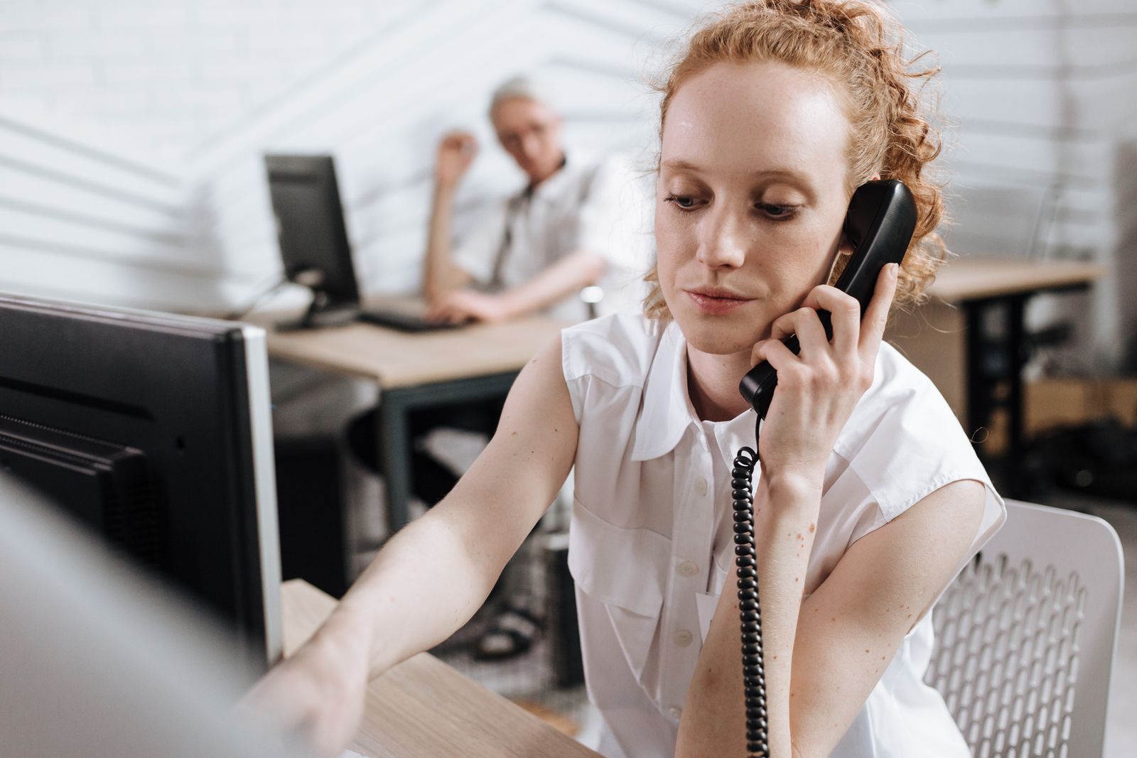 Rozmowa telefoniczna przy biurku — kontakt z sekretariatem