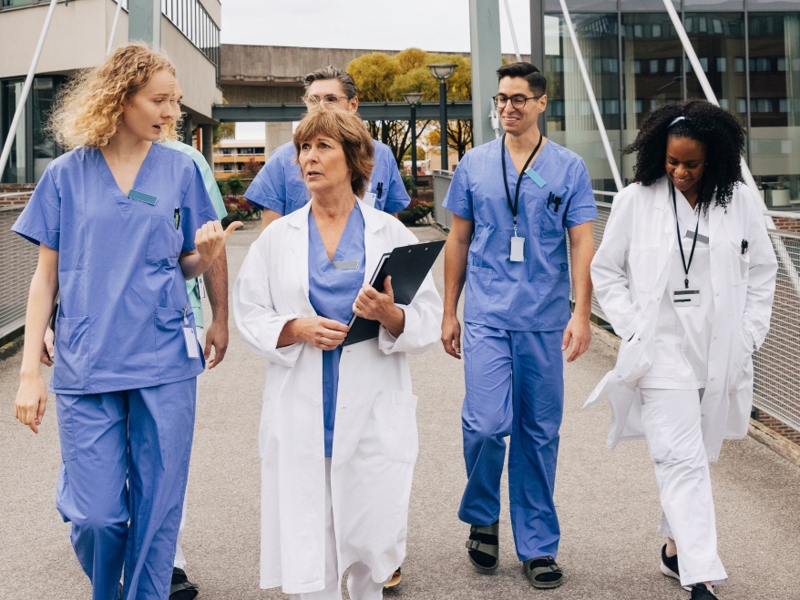 Doctors and nurses walking together outside a hospital