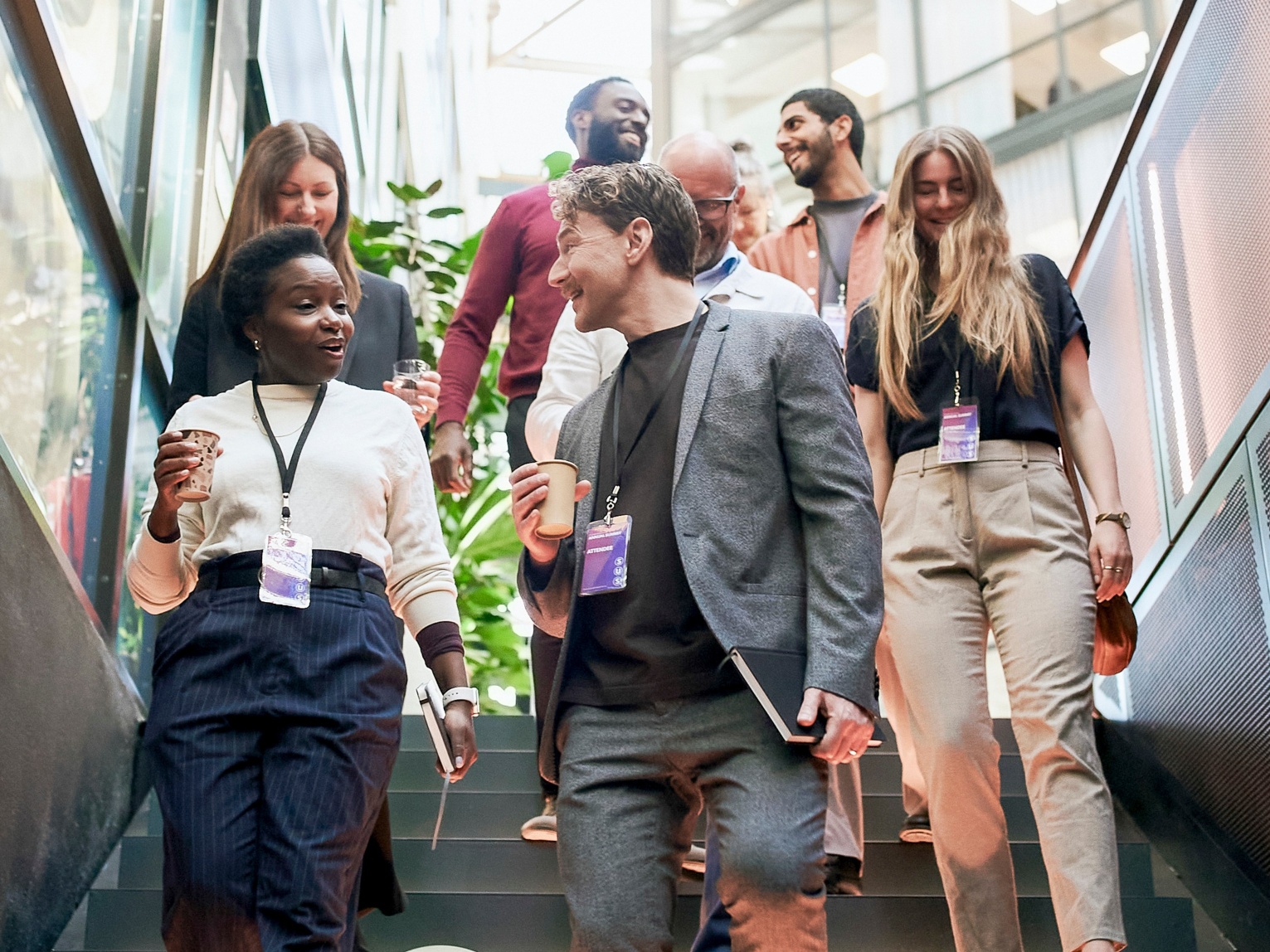 Conference attendees with name badges walking down a staircase