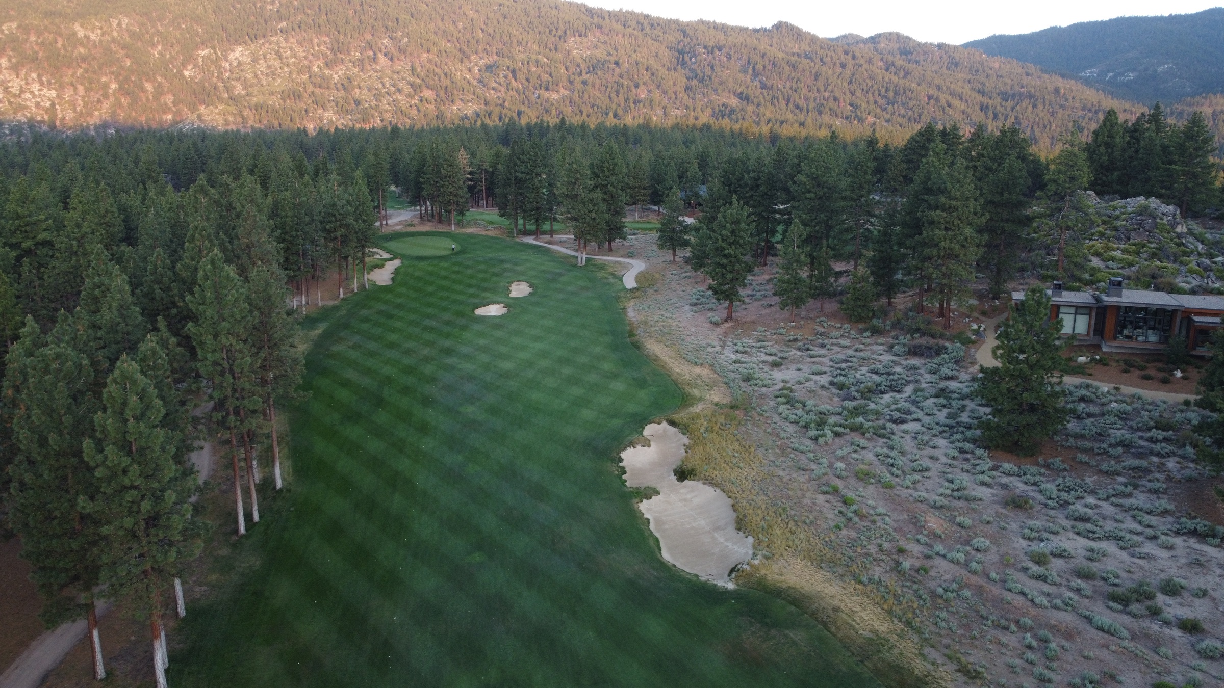 Aerial view of Clear Creek Tahoe golf course winding through mountain forest.