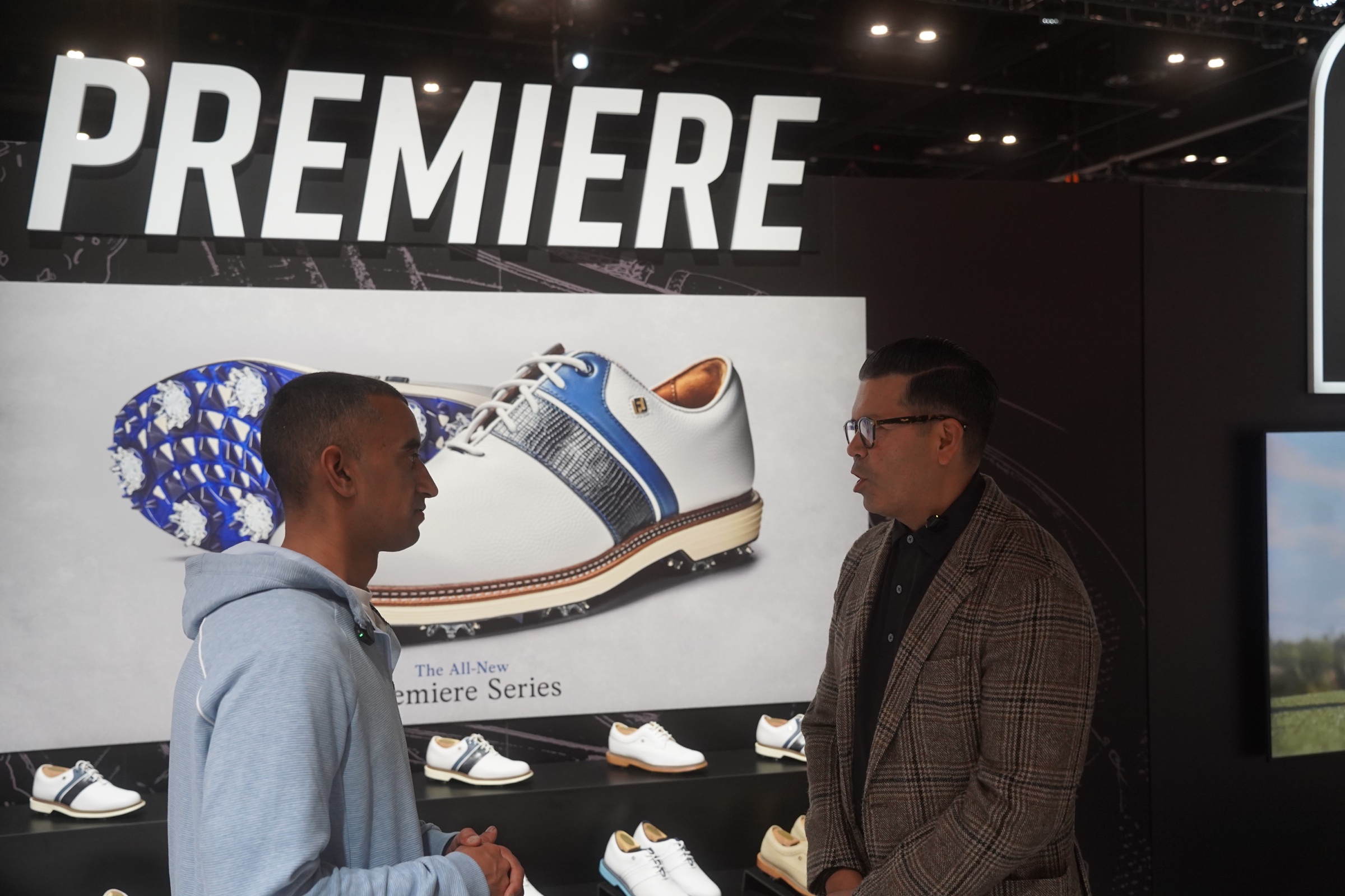 Two people discuss FootJoy golf shoes at the Premiere Series display.