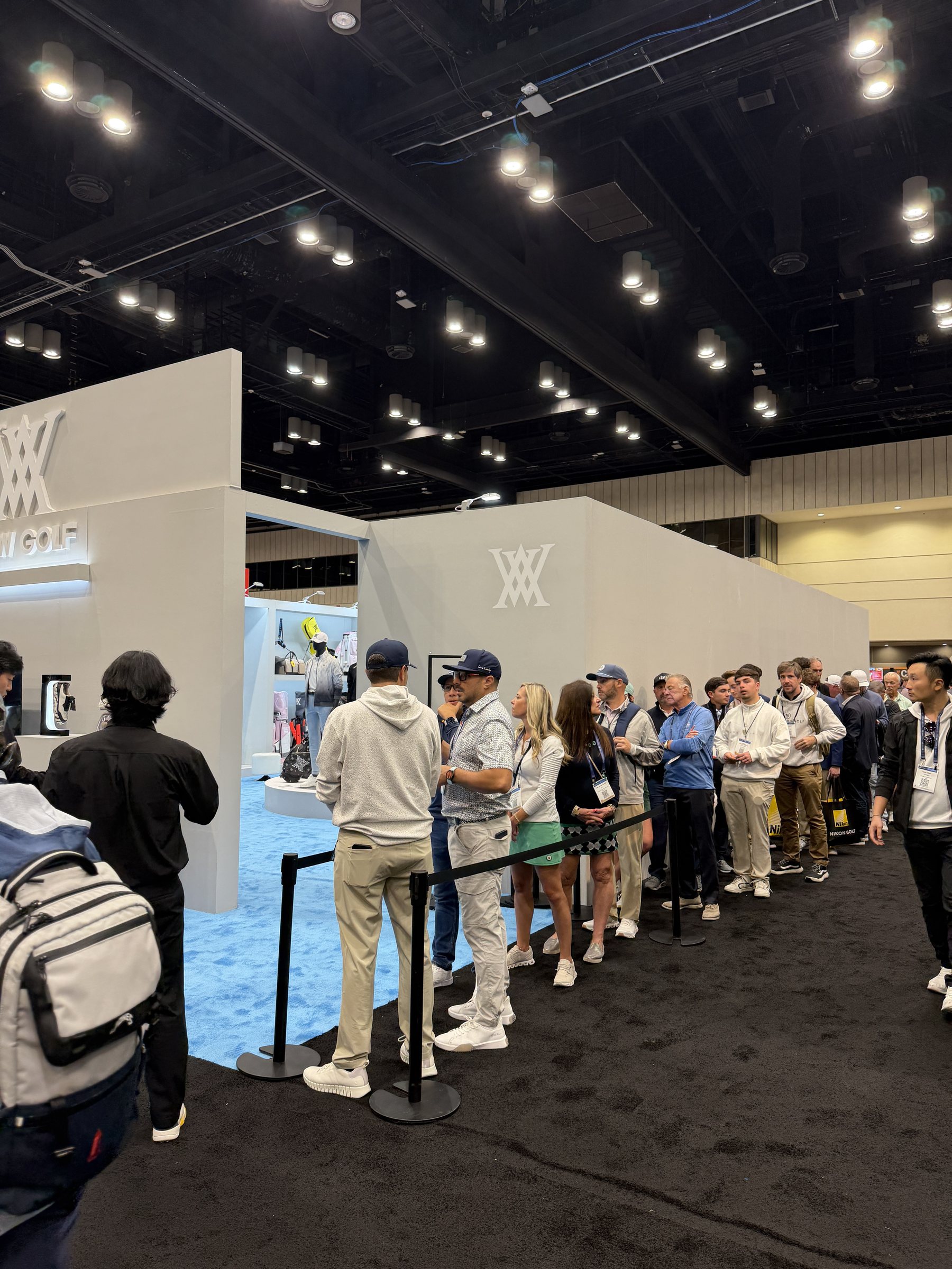 Crowd gathered at a busy brand booth during the PGA Show.