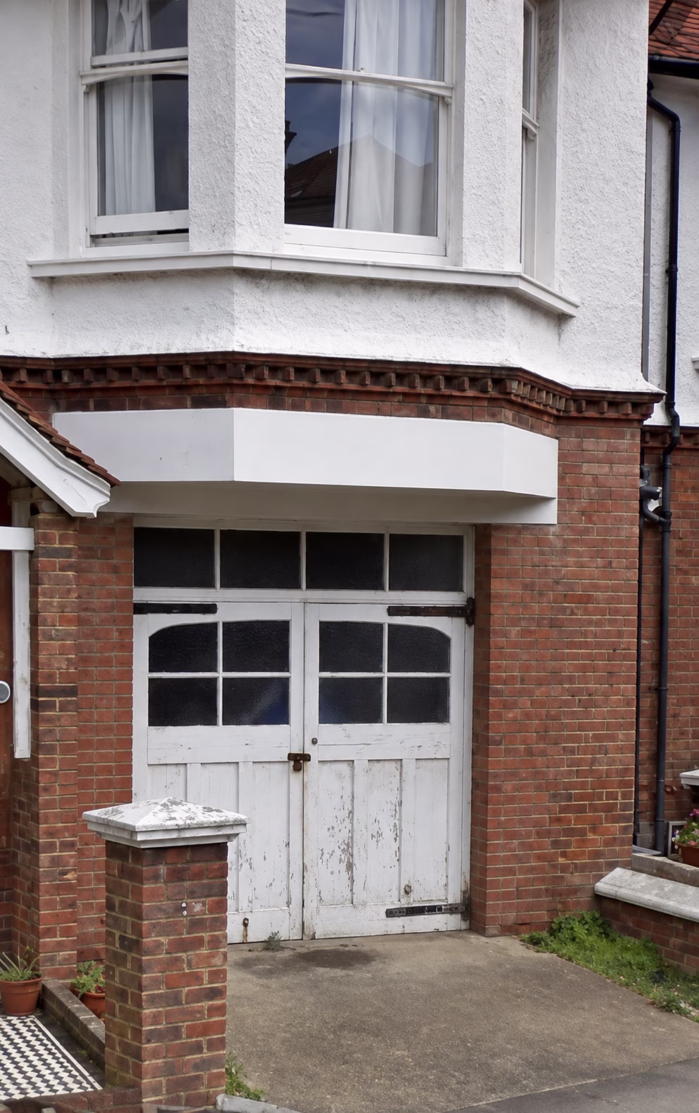 Old garage door before being converted into a brick bay window in Worthing