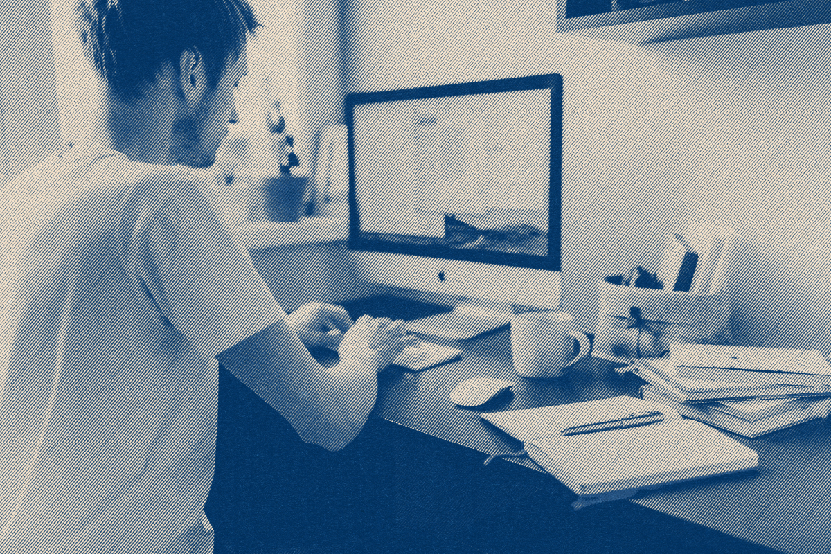 Freelancer at a desktop computer with a notebook