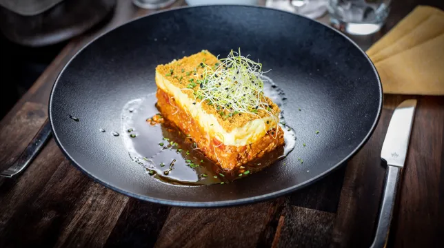 Parmentier gratiné surmonté de jeunes pousses, servi avec son jus au restaurant Les Terrasses d'Illkirch
