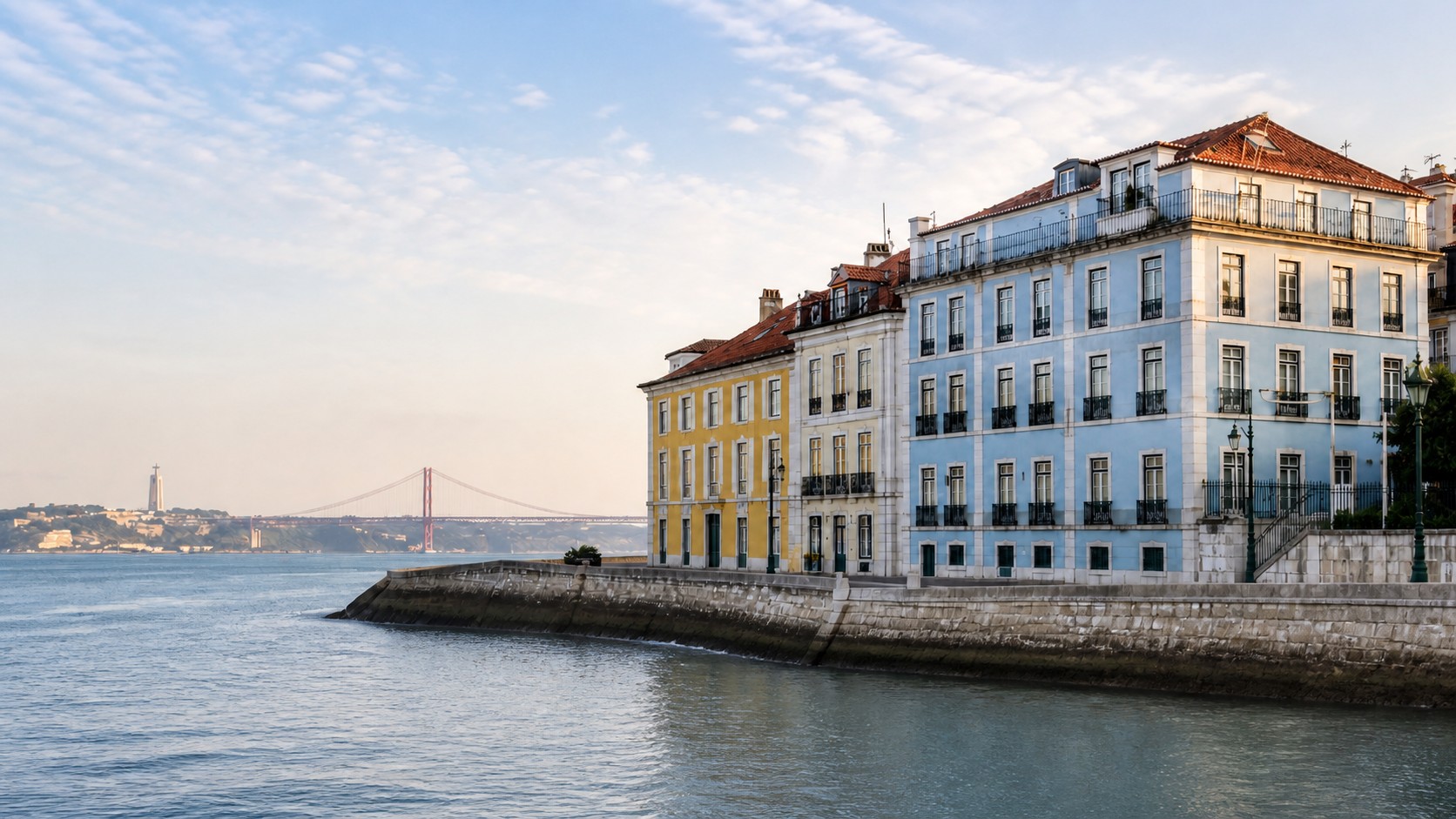Lisbon waterfront with historic buildings and the 25 de Abril Bridge