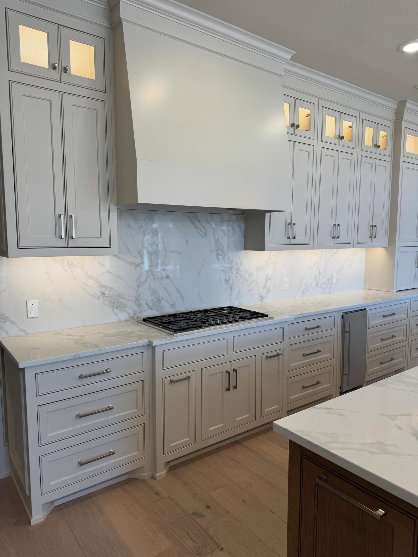 Custom range hood and marble backsplash kitchen