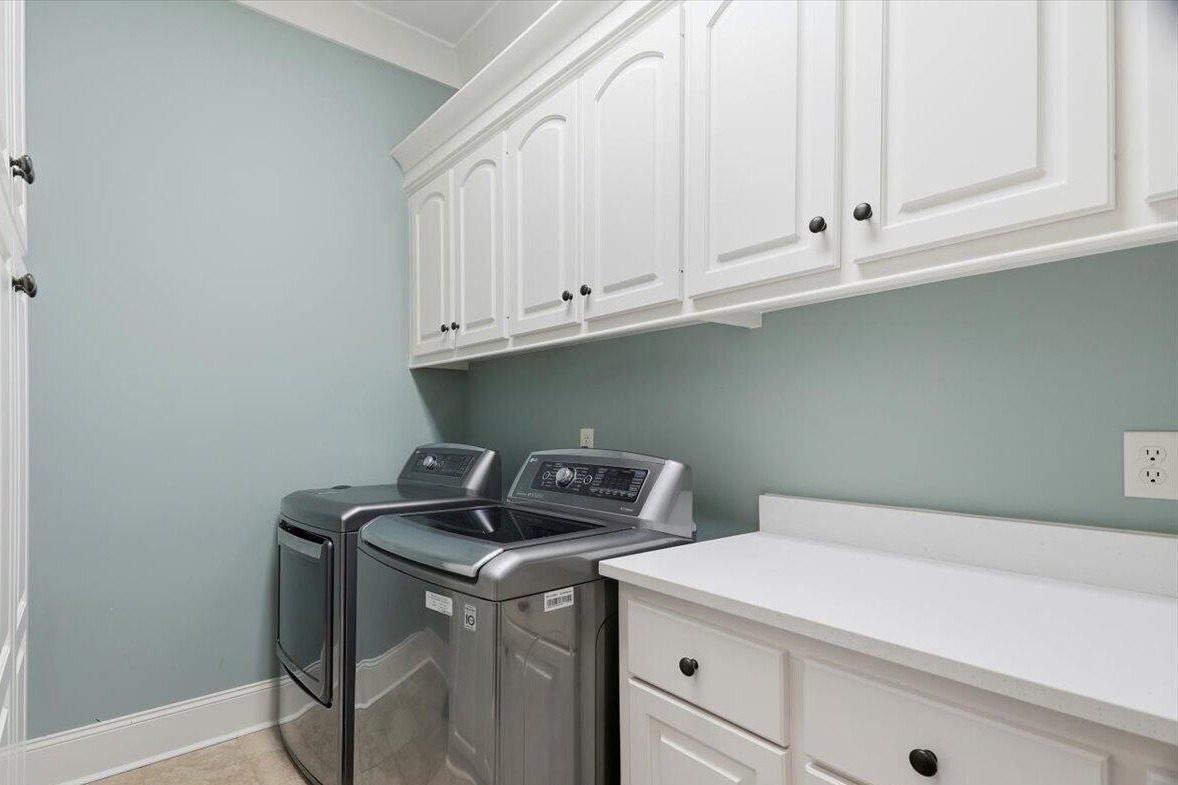 Laundry room with washer, dryer, and cabinets