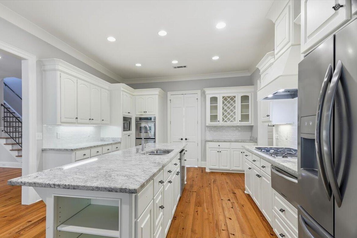 Kitchen island with granite counters and white cabinetry