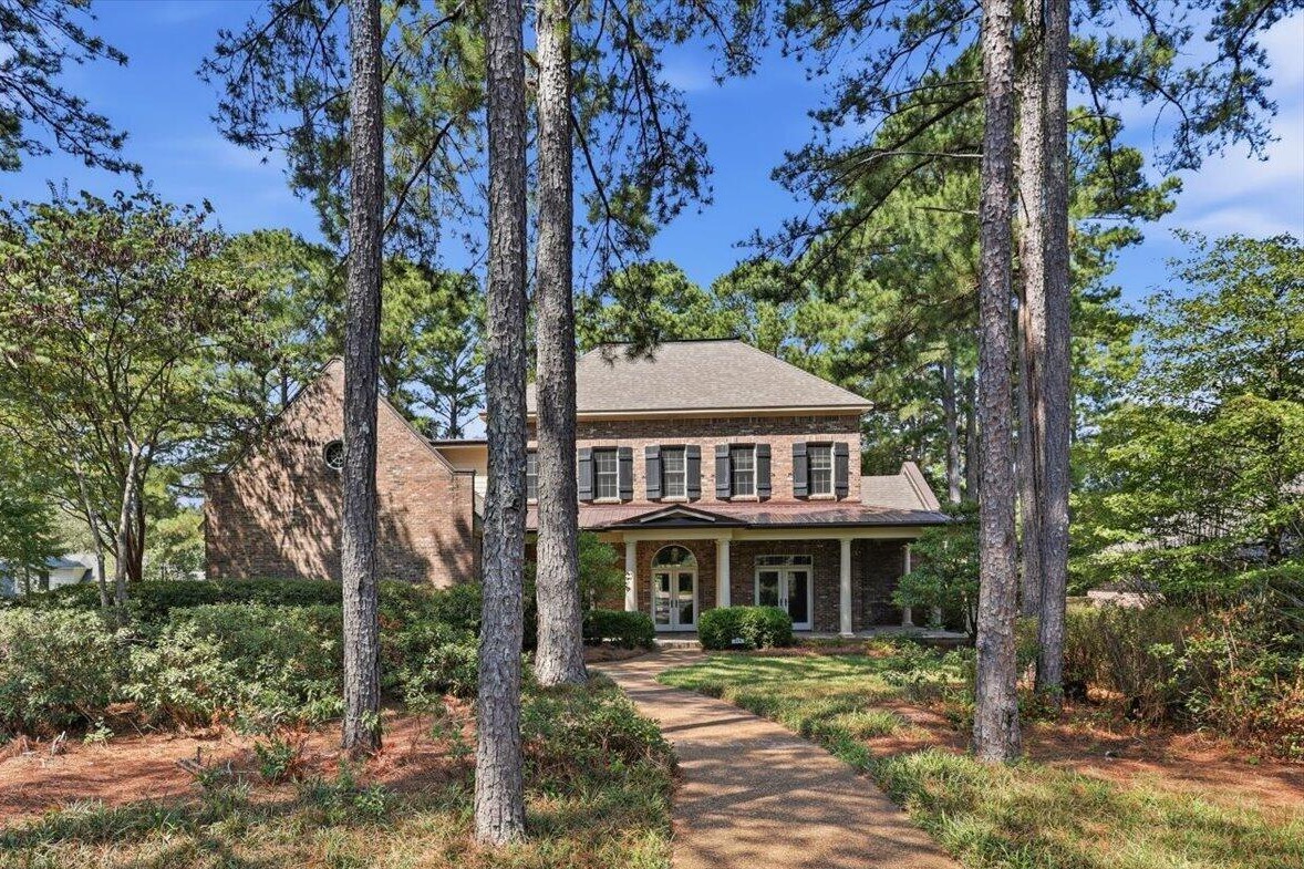 Front walkway through tall pines to the brick home in Knightsbridge, Madison, MS