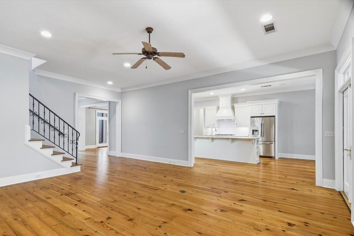 Living room with heart pine floors opening to the kitchen