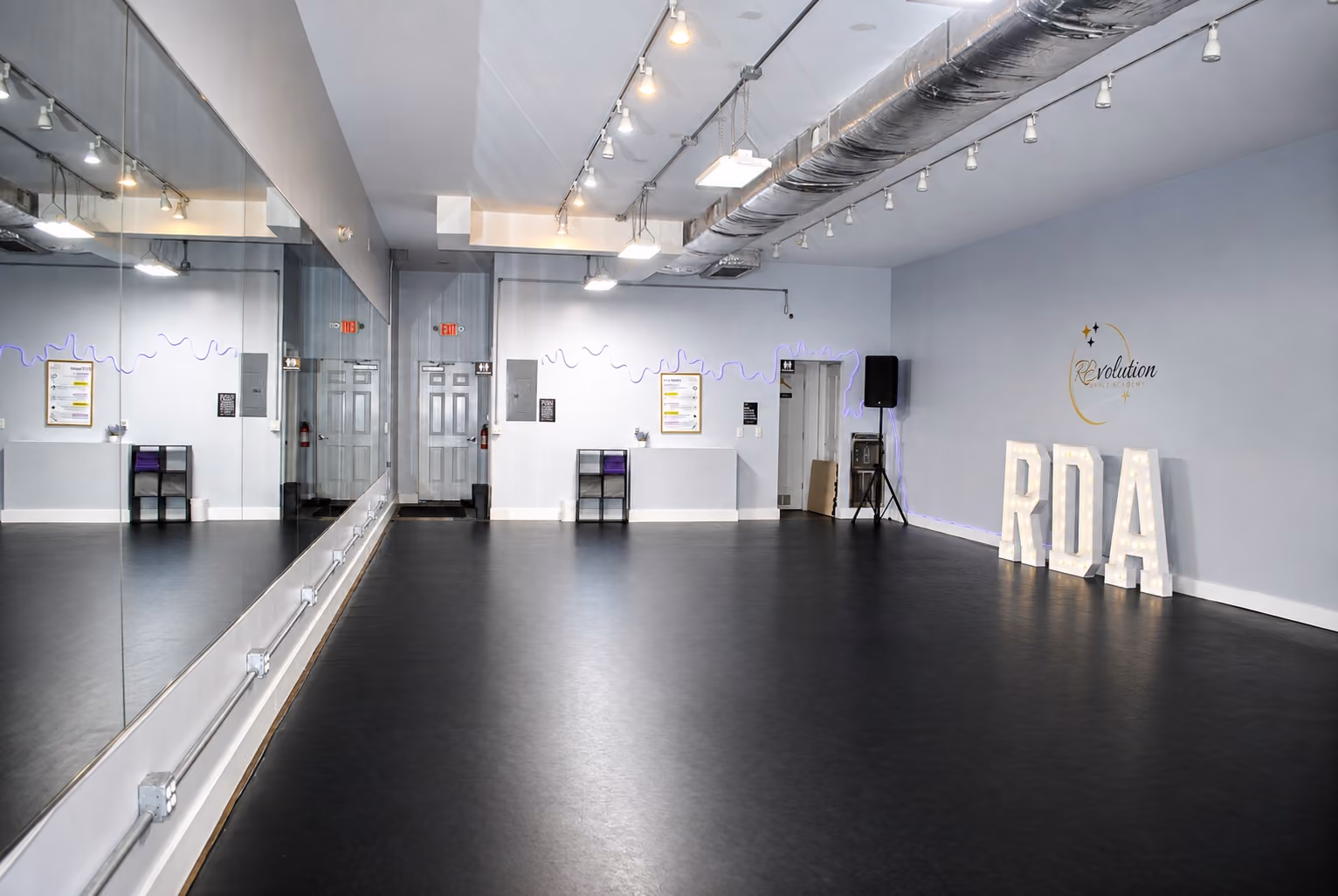 Dance studio interior at Revolution Dance Academy's Annex, 11 Hillside Ave, Tenafly NJ — mirrors, barres and lit RDA letters