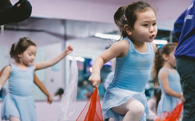 Preschool dancers leaping with scarves during class at Revolution Dance Academy in Tenafly