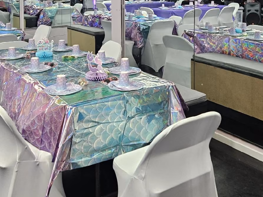Mermaid-themed party table with iridescent tablecloth and place settings in the RDA studio