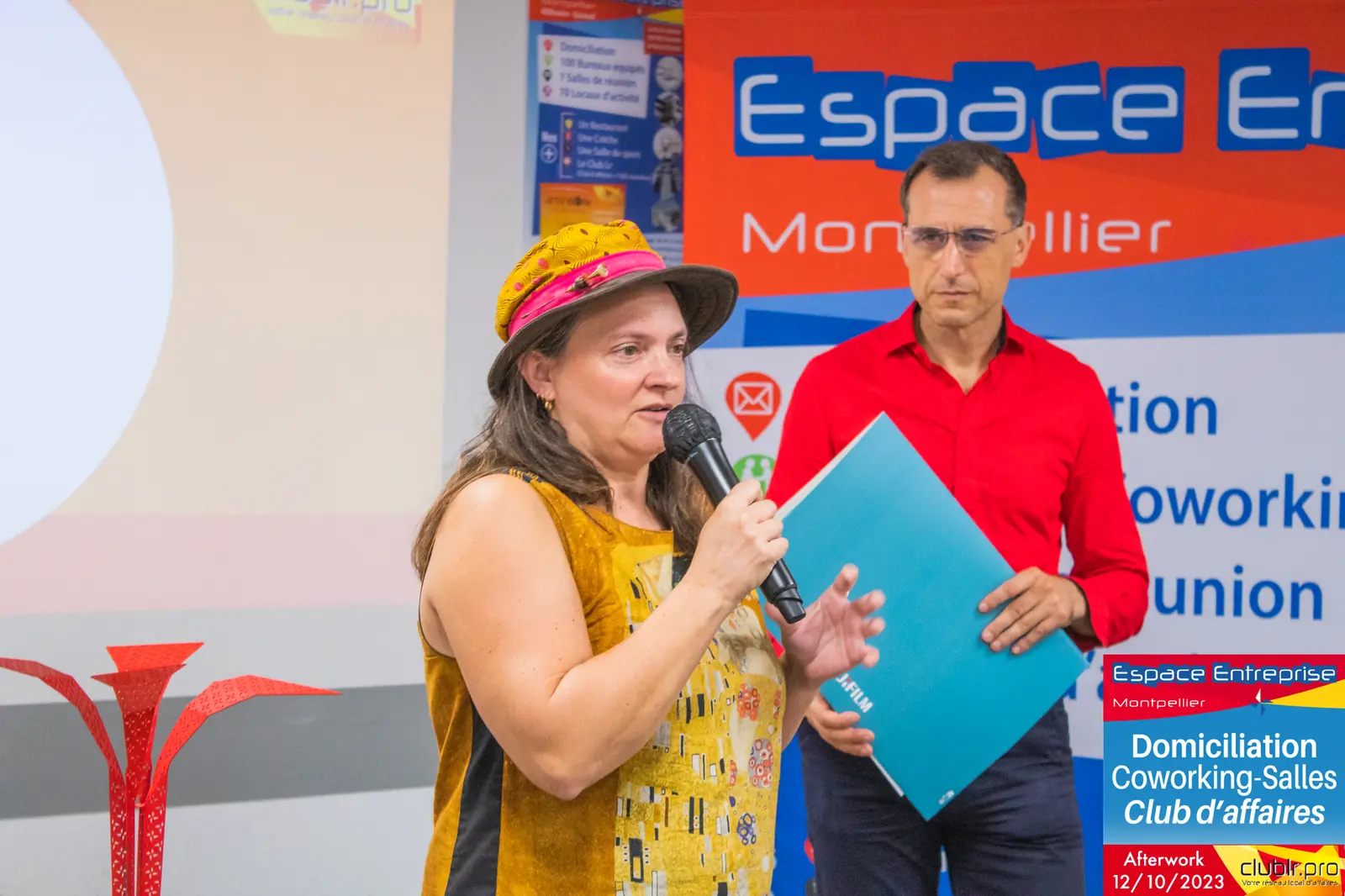 Afterwork Pitch Elevator Club LR octobre 2023 à Montpellier : entrepreneure au micro avec l'animateur devant le fond
