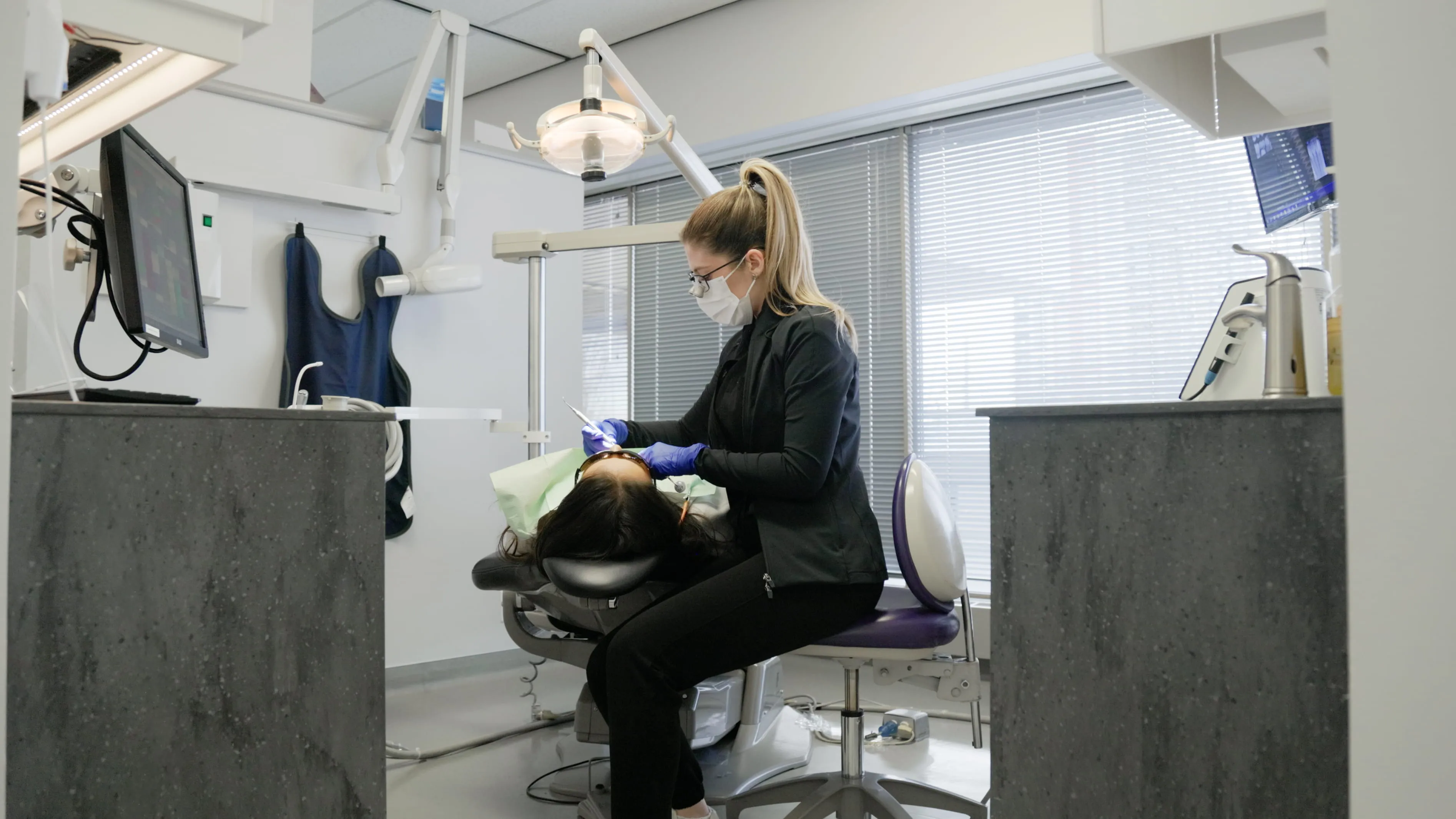 Registered dental hygienist cleaning a patient's teeth at Macleod Trail Dental