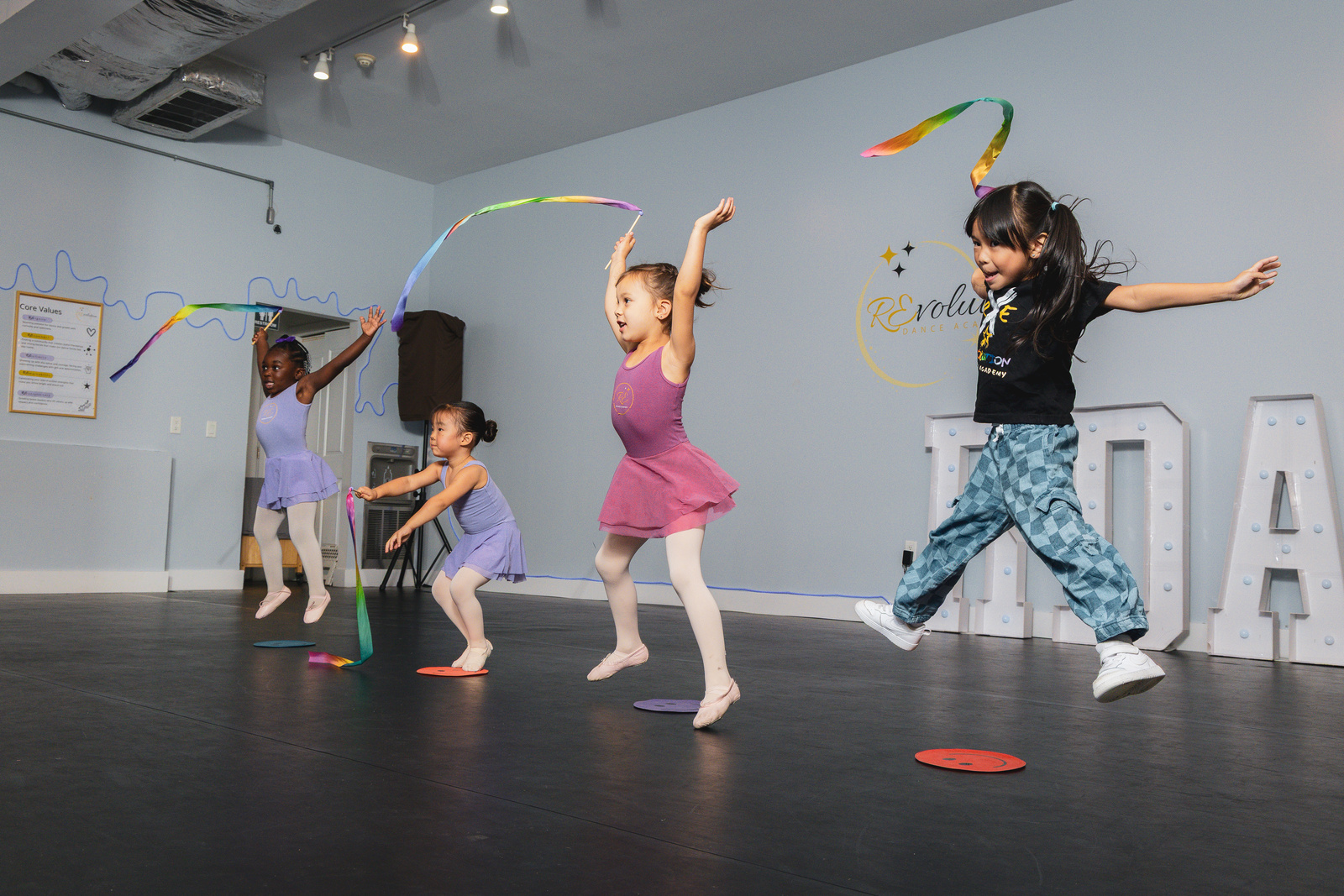Preschool dancers waving ribbons during a REvBabies class at Revolution Dance Academy