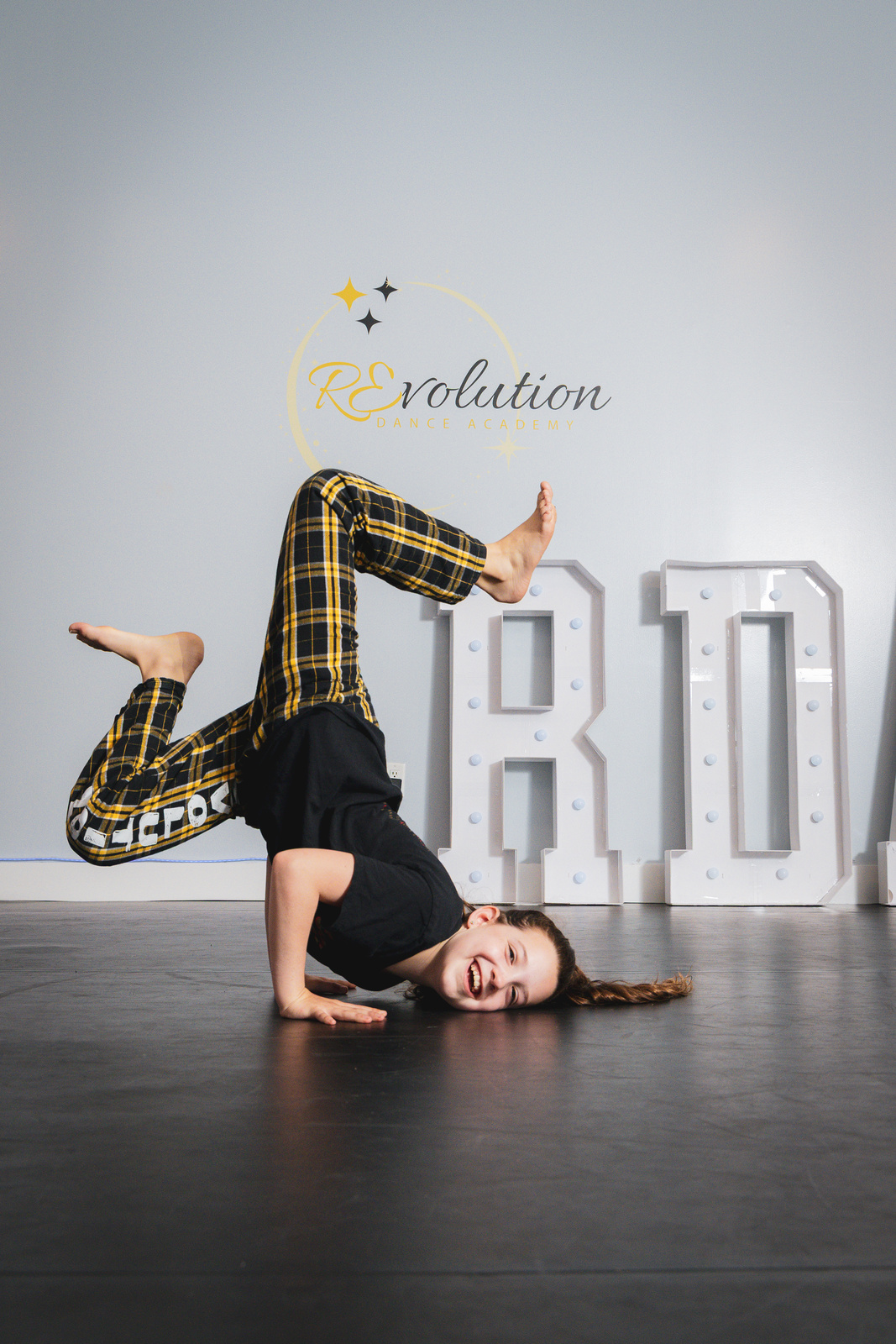 A breaking student holding a freeze in front of the RDA marquee letters