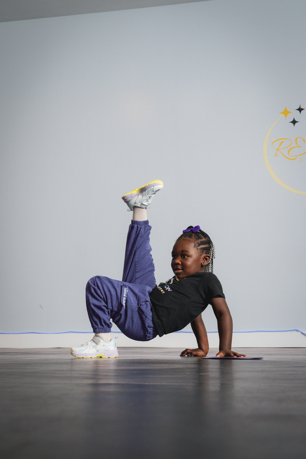 A young breaker practicing a freeze during breaking class at Revolution Dance Academy