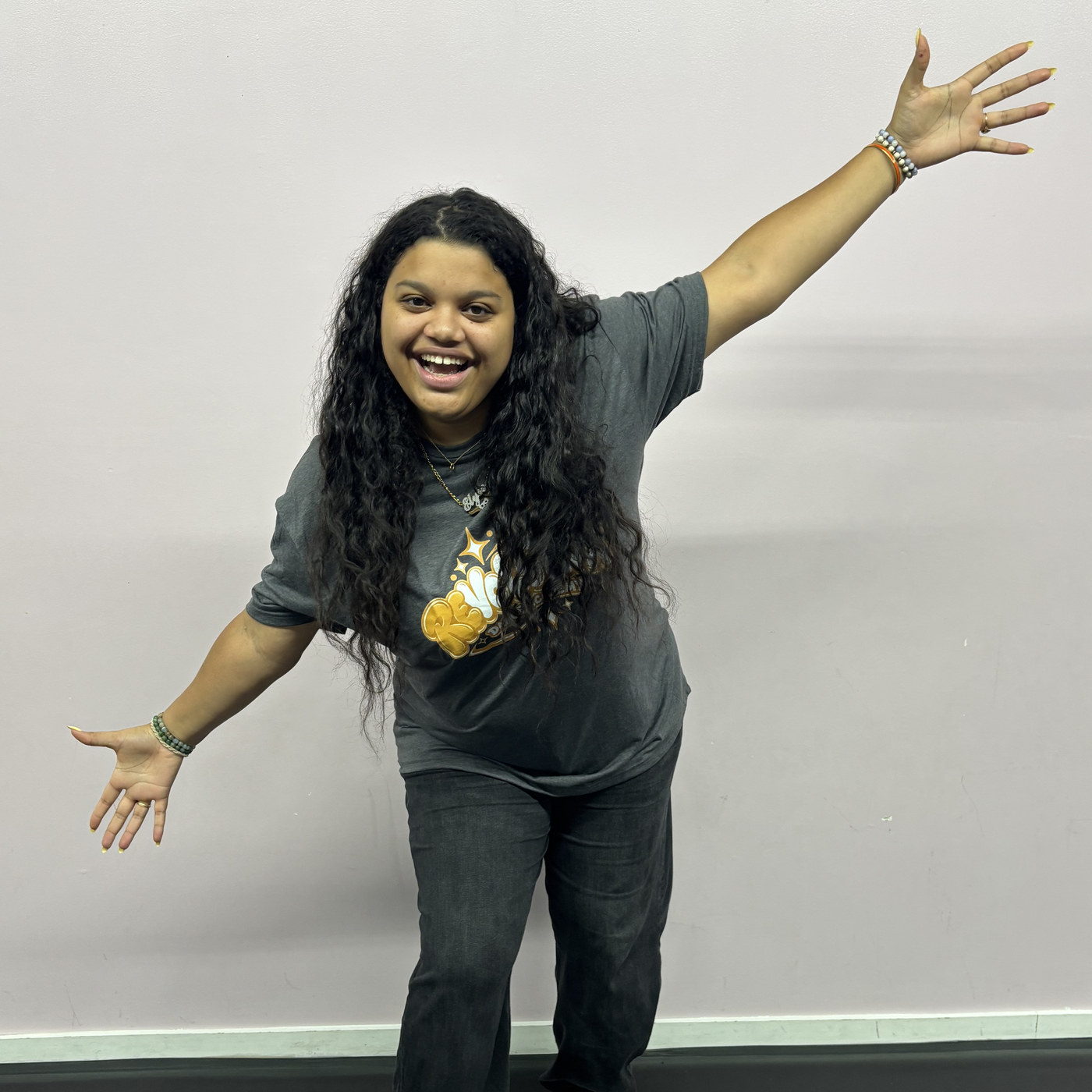 Elyse Rosario with arms outstretched in the Revolution Dance Academy studio