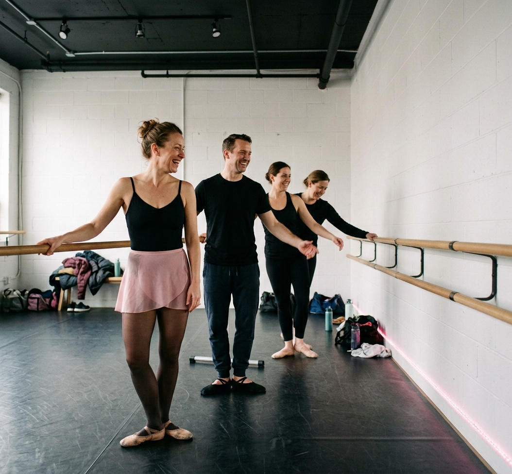 Four adult ballet students laughing at the barre during a beginner class at Revolution Dance Academy