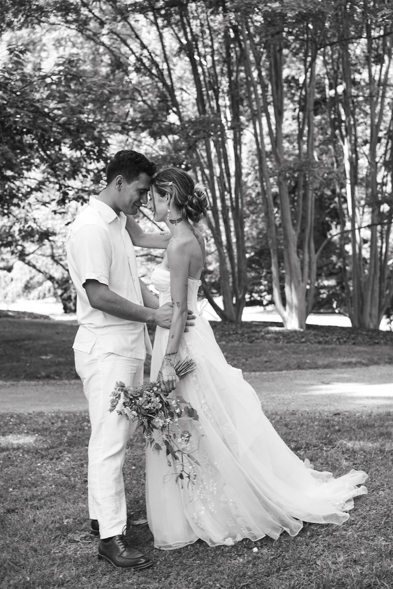 Black-and-white portrait of a newly married couple holding each other outdoors
