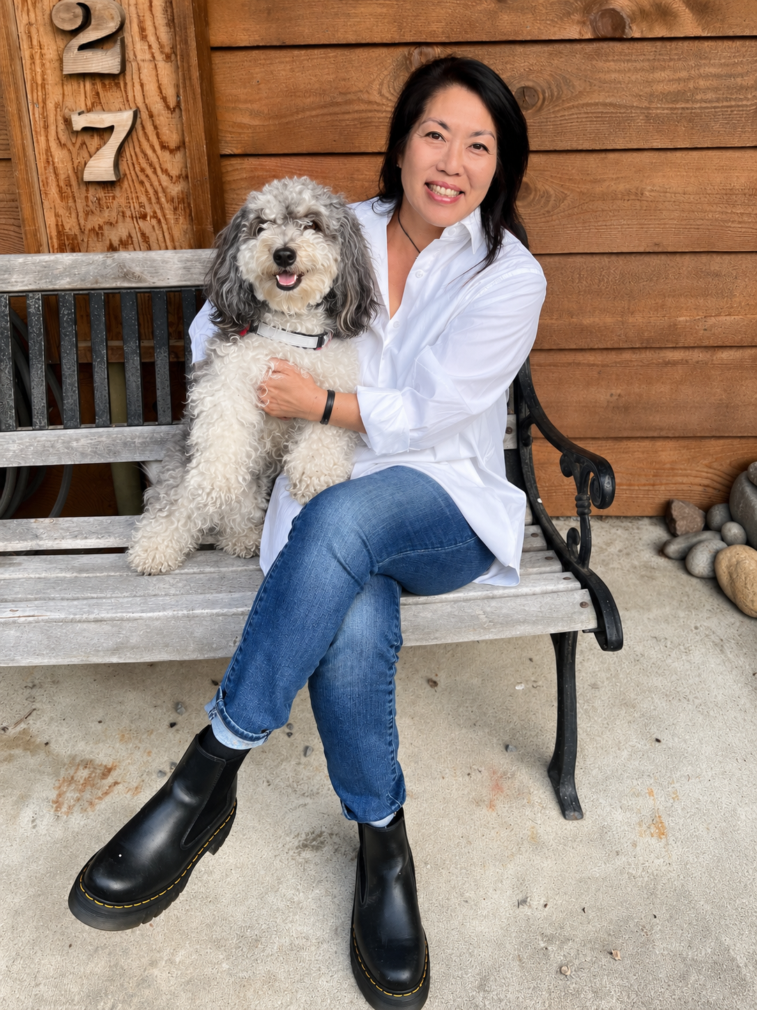 Kelly smiling with Suki facing the camera outside their home
