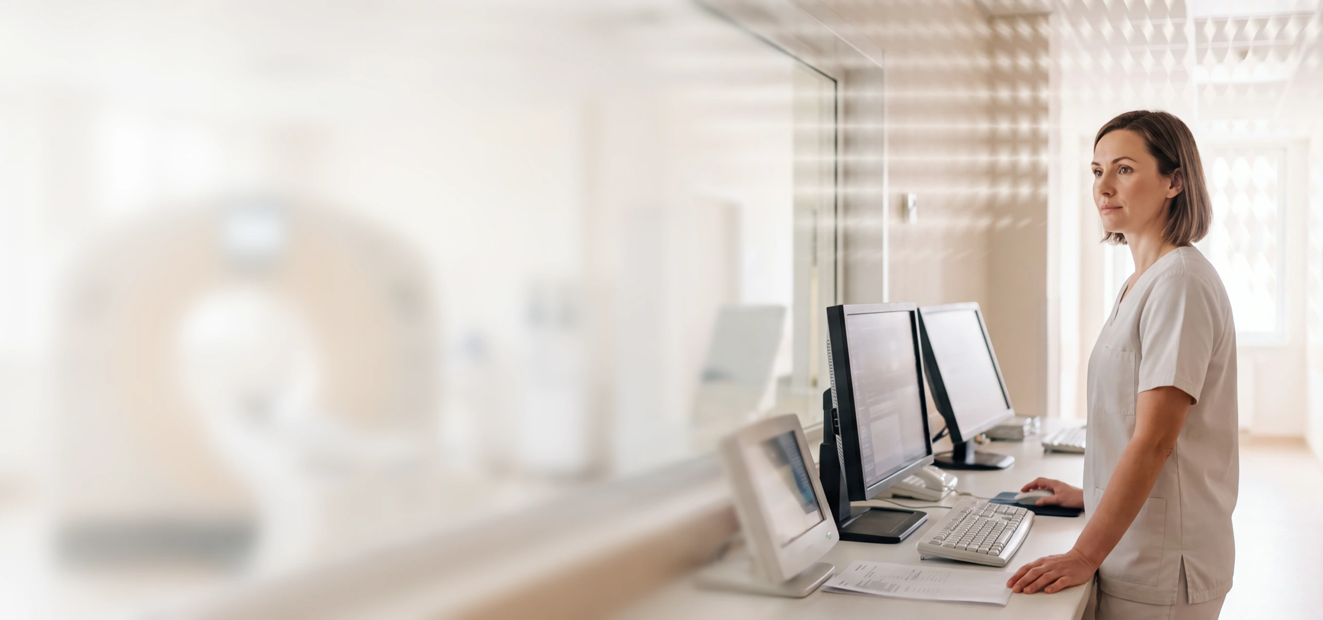 Healthcare professional at a desk using a computer in a bright office setting