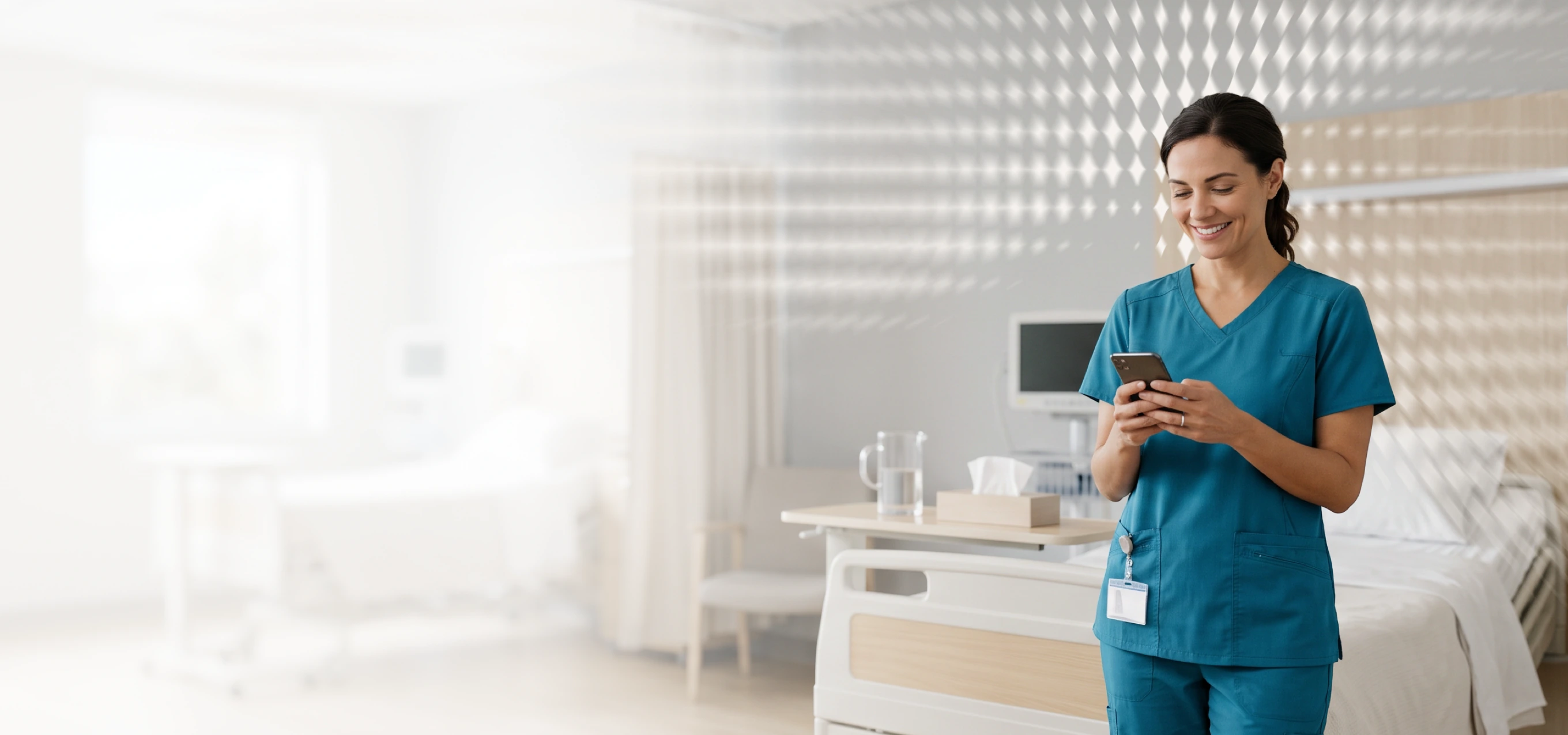Smiling nurse in scrubs using a phone in a modern hospital room