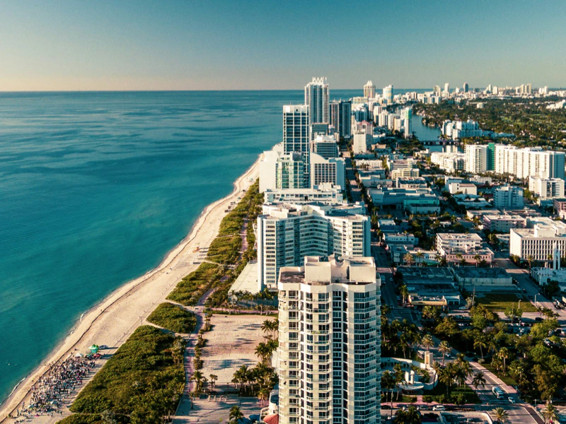 Aerial view of Miami beachfront with high-rise buildings and palm trees