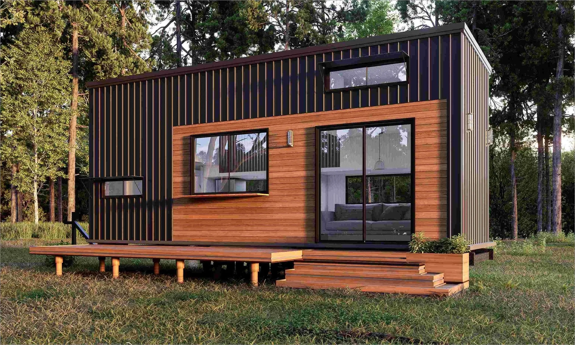 Modern tiny house with black vertical siding and wooden accents, featuring a wooden deck and large glass sliding doors, set in a forested area with grass and trees around.