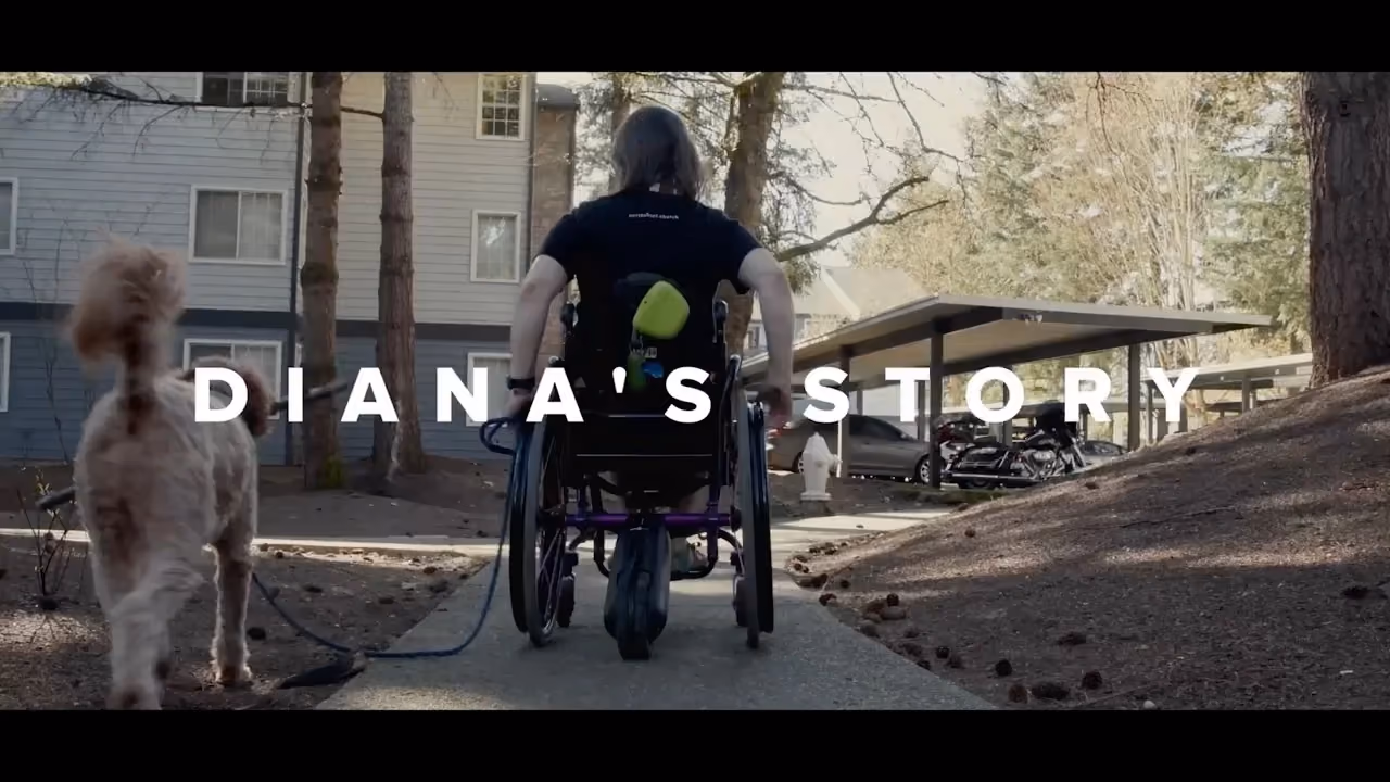 Diana, who shares her story, seated in her wheelchair with her dog.