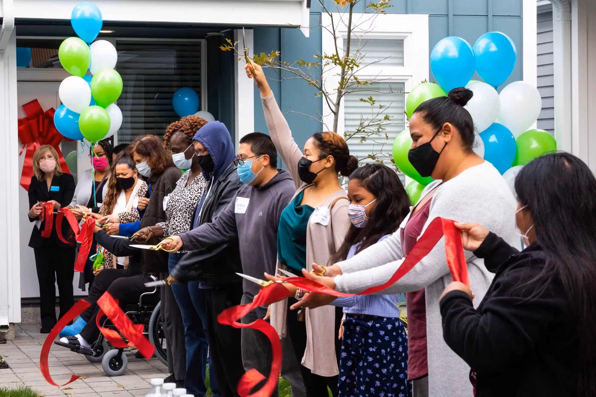 A ribbon-cutting celebration with balloons for a Habitat for Humanity project.