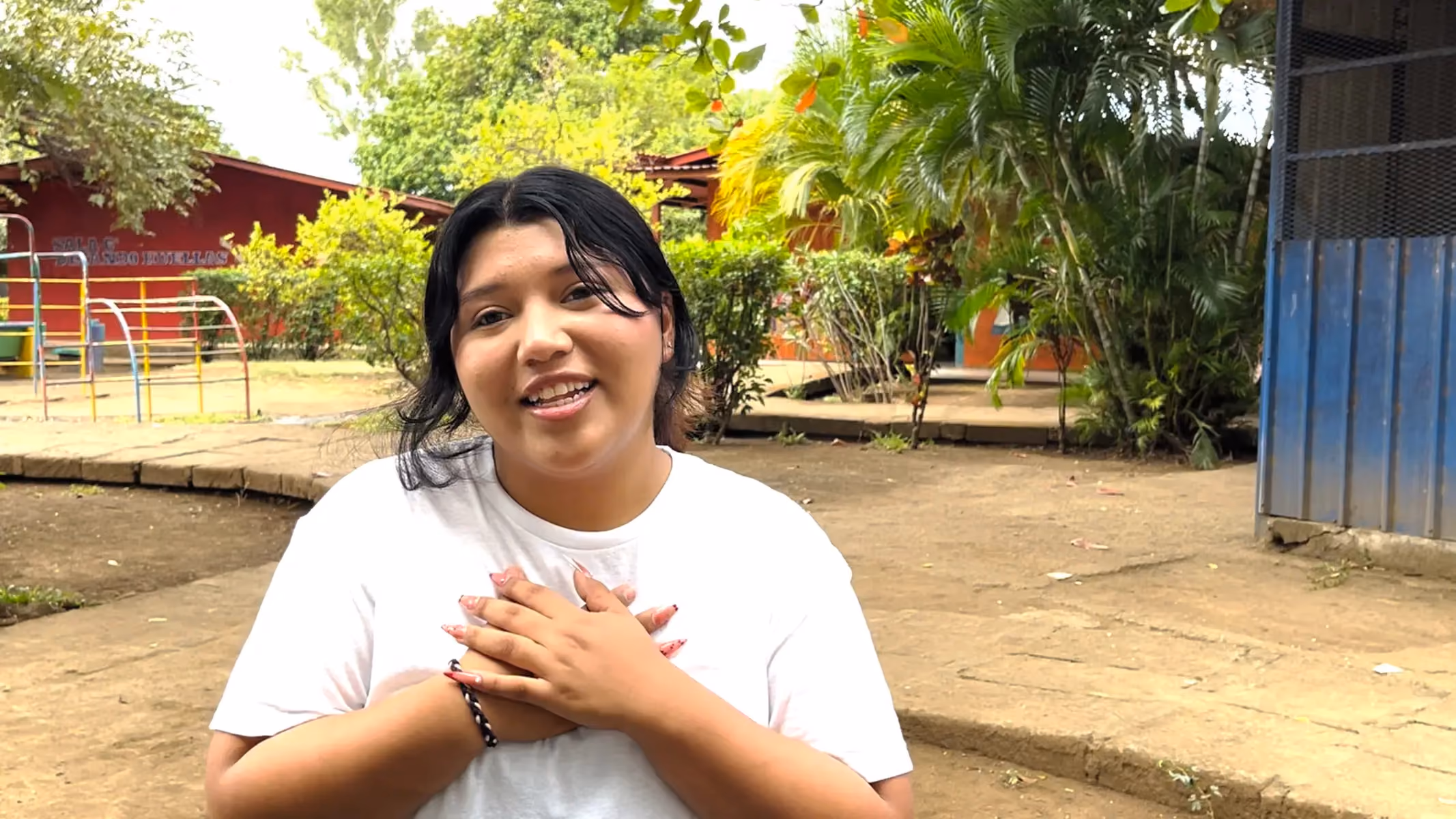 A woman smiling outdoors, sharing her Los Cedros Nicaragua story.