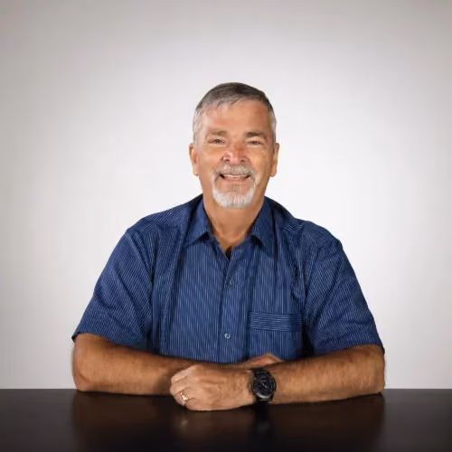 Friedbert Wall, an Overseer at Northshore Church, smiling at his desk.