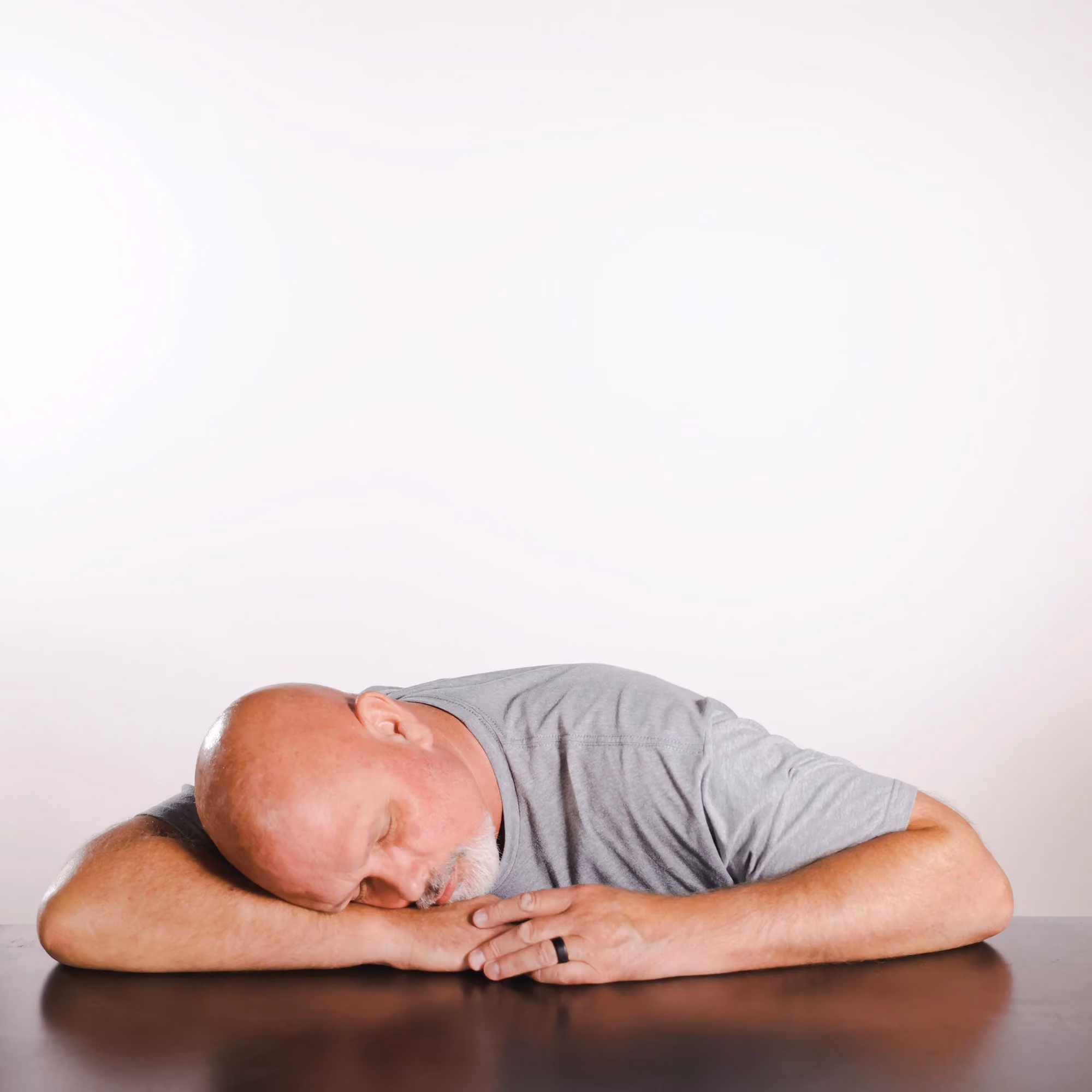 Kerry Warren pretending to sleep on a table in a lighthearted staff photo.