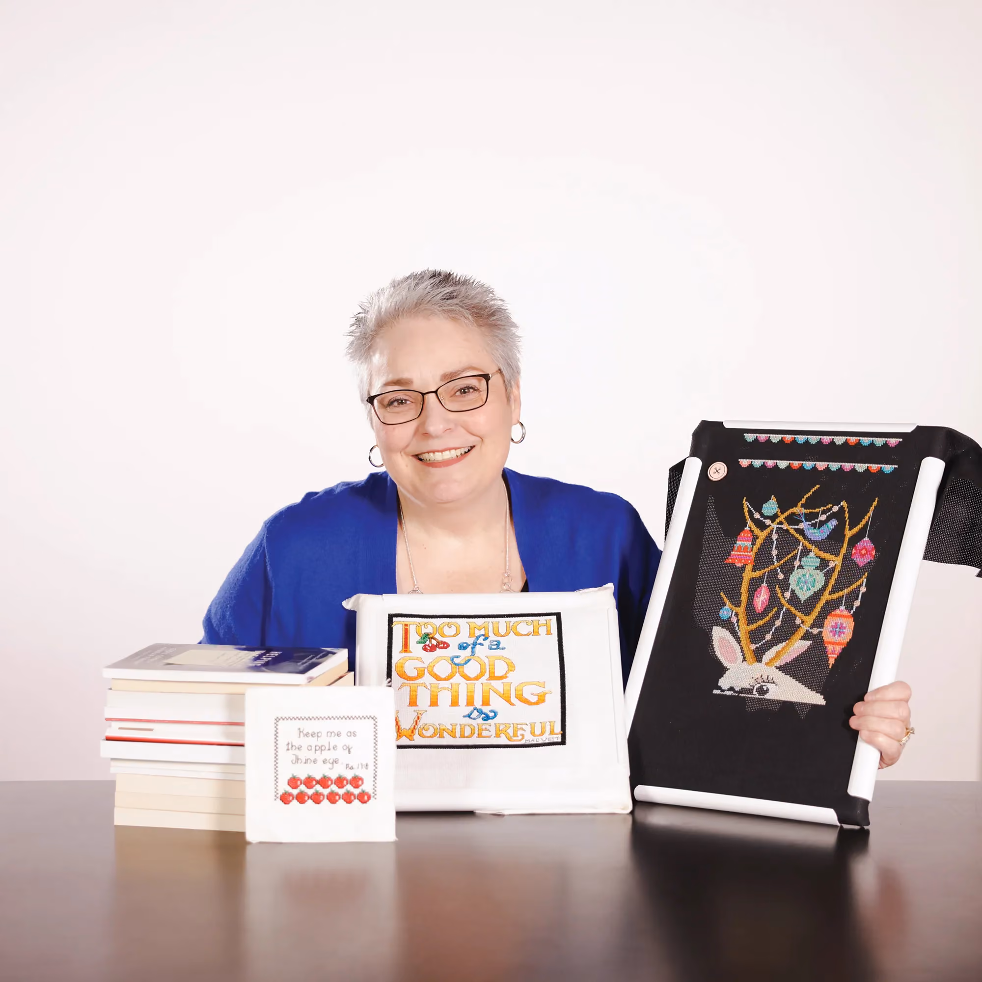 Kellie Herriott holding embroidery designs in a candid staff photo.