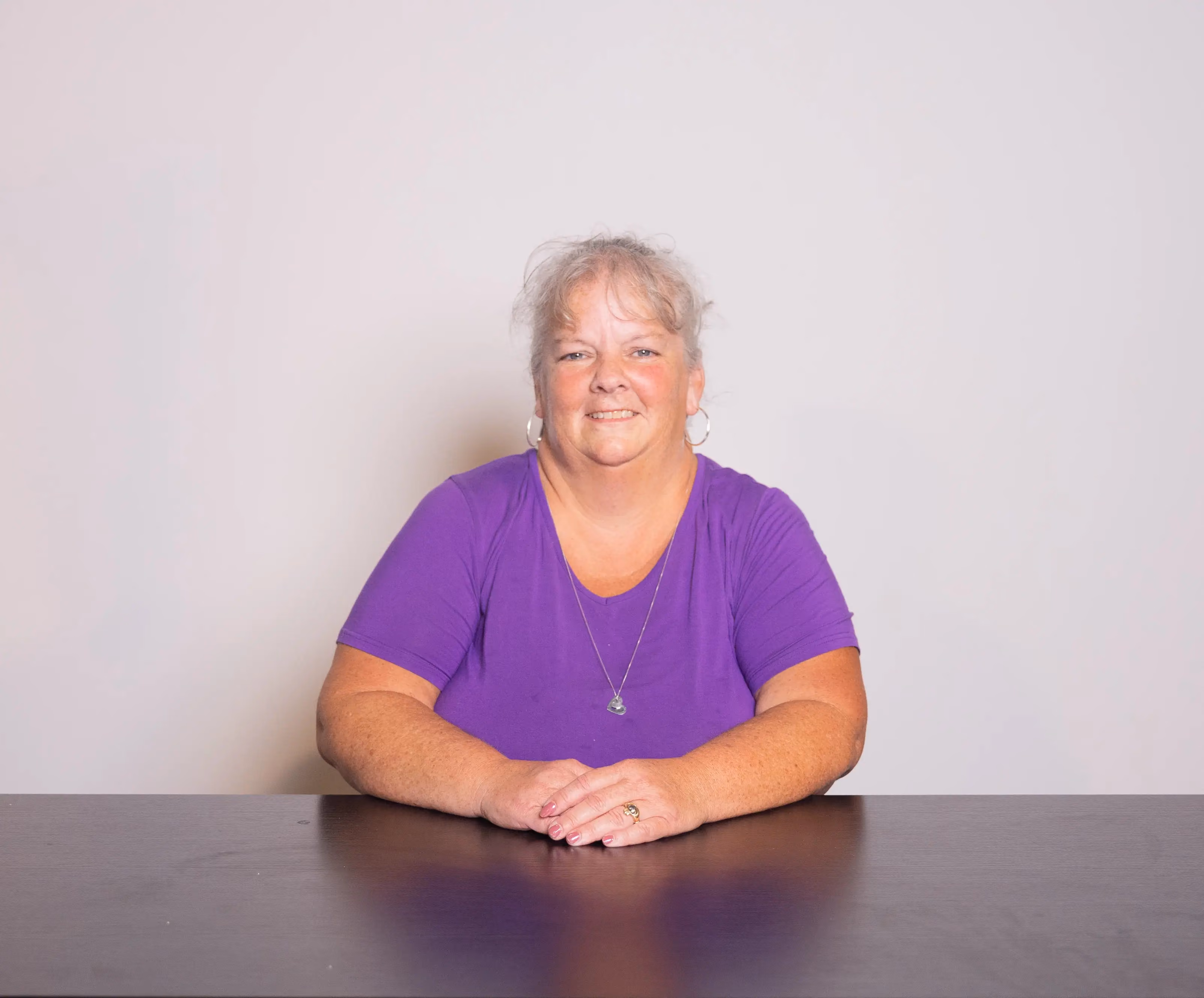 Linda Smith smiling in a purple shirt in a candid staff photo.
